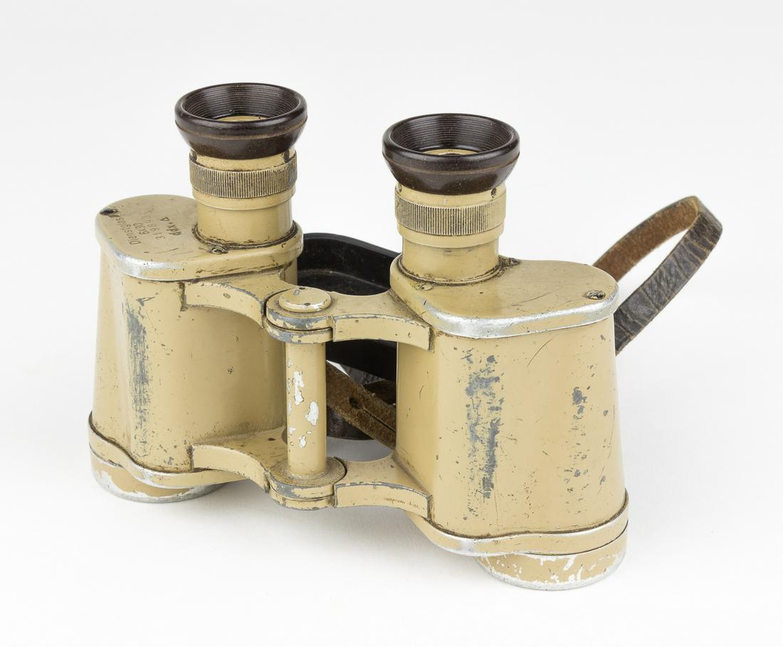 WEHRMACHT BINOCULARS BY VOIGTLANDER: Pair of Wehrmacht 'Dienstglas' ('service glass') binoculars, 6x30 power, coated with 'ordnance tan' pant and fitted with a leather neck strap securing a black rubber eyepiece cover. The top of the rig