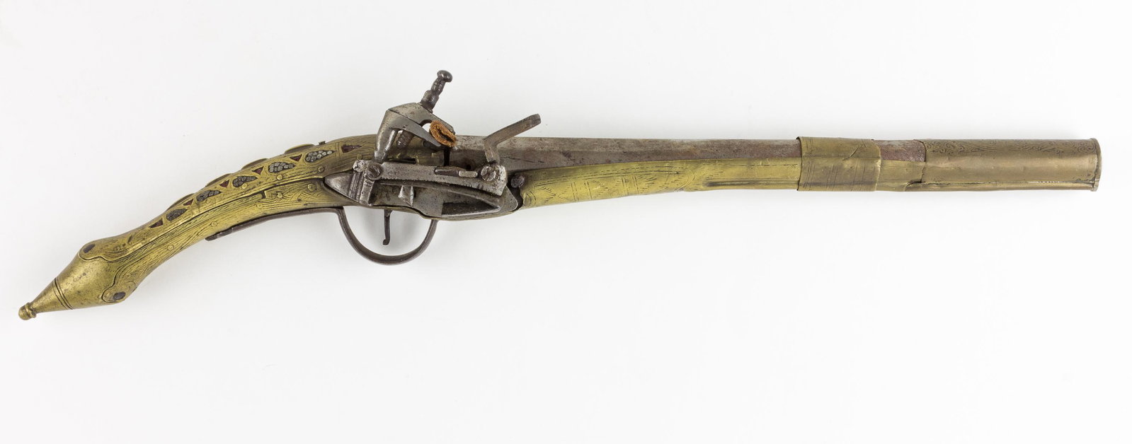 BRASS-MOUNTED FLINTLOCK PISTOL: North African or Middle Eastern flintlock pistol, 12' barrel, 20' overall, the wood stock completely encased in brass sheets with engraved geometric and floral decorations and a few remaining inlaid r