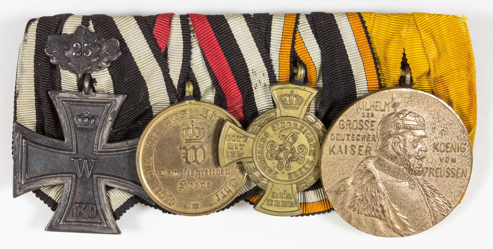 FRANCO-PRUSSIAN WAR VETERAN'S MEDAL BAR: Bar of four medals related to a veteran's service in the Franco-Prussian War of 1870-1871. The bar is comprised of an 1870 Iron Cross, Second Class with 25-Year Jubilee clasp, a War Commemorative Meda