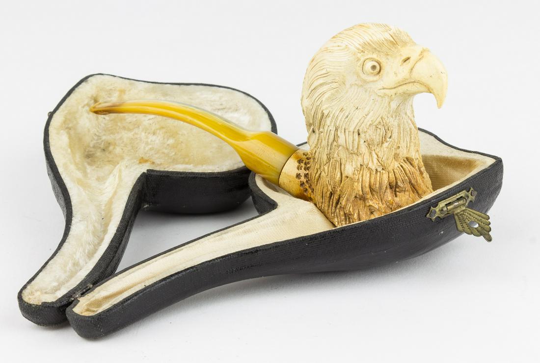 BALD EAGLE MEERSCHAUM PIPE: A tobacco pipe, approx. 6.25 in. long, featuring a meerschaum bowl finely carved in the detailed likeness of the head of an American bald eagle, and fitted with an amber composite stem. The bowl is so