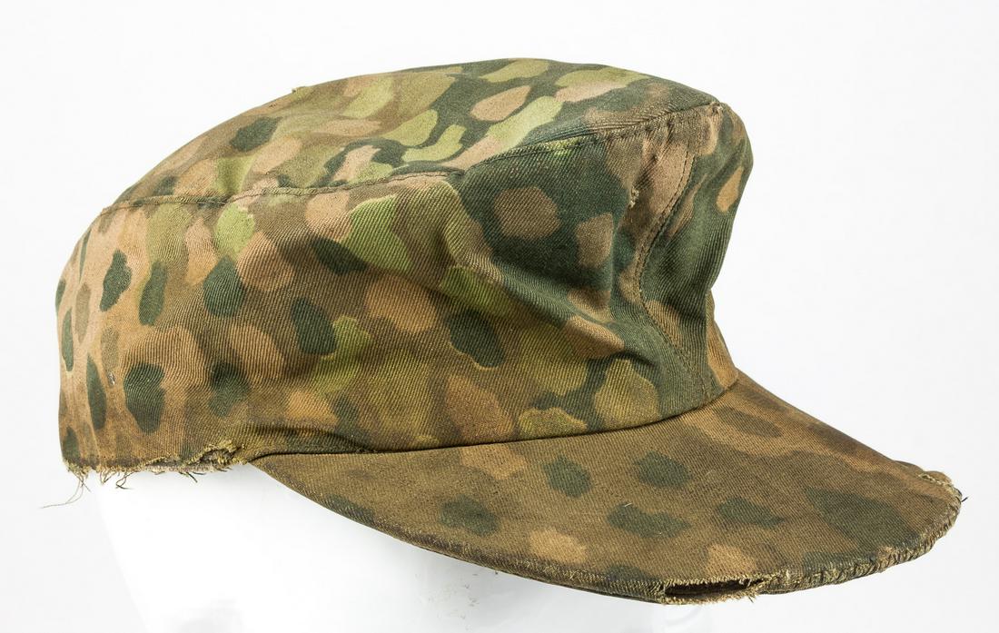 WAFFEN-SS DOT PATTERN FIELD CAP: Waffen-SS Pea Dot Pattern Field Cap, very heavily worn and soiled, partly split at the edge of the brim exposing the leather reinforcement within, with an older split there bearing a hand-sewn repair.