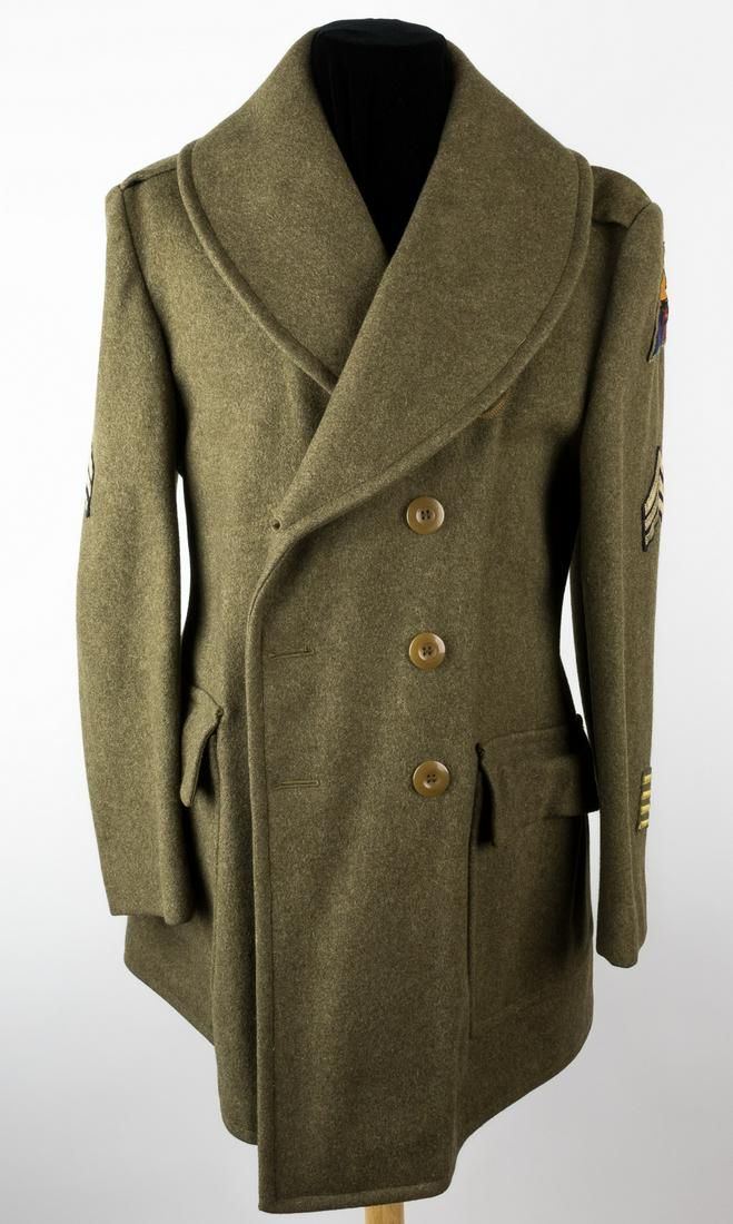 1ST ARMORED DIVISION SERGEANT'S UNIFORM OVERCOAT: Heavy khaki wool overcoat, as worn by U.S. troops during World War II, closed at front with two rows of four yellow composite buttons. The right-hand shoulder bears the insignia patch of the XIII Corp