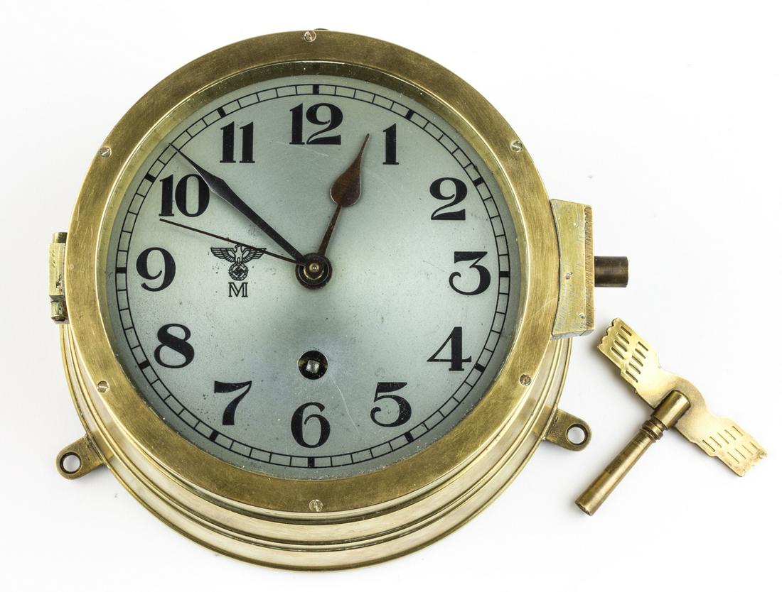 KEY-WOUND KRIEGSMARINE WALL CLOCK: Kriegsmarine clock believed to have been intended for, or removed from, a German Kriegsmarine surface ship. The clock shows obvious signs of extended use, with a 6 in. silver face, a brass case and be