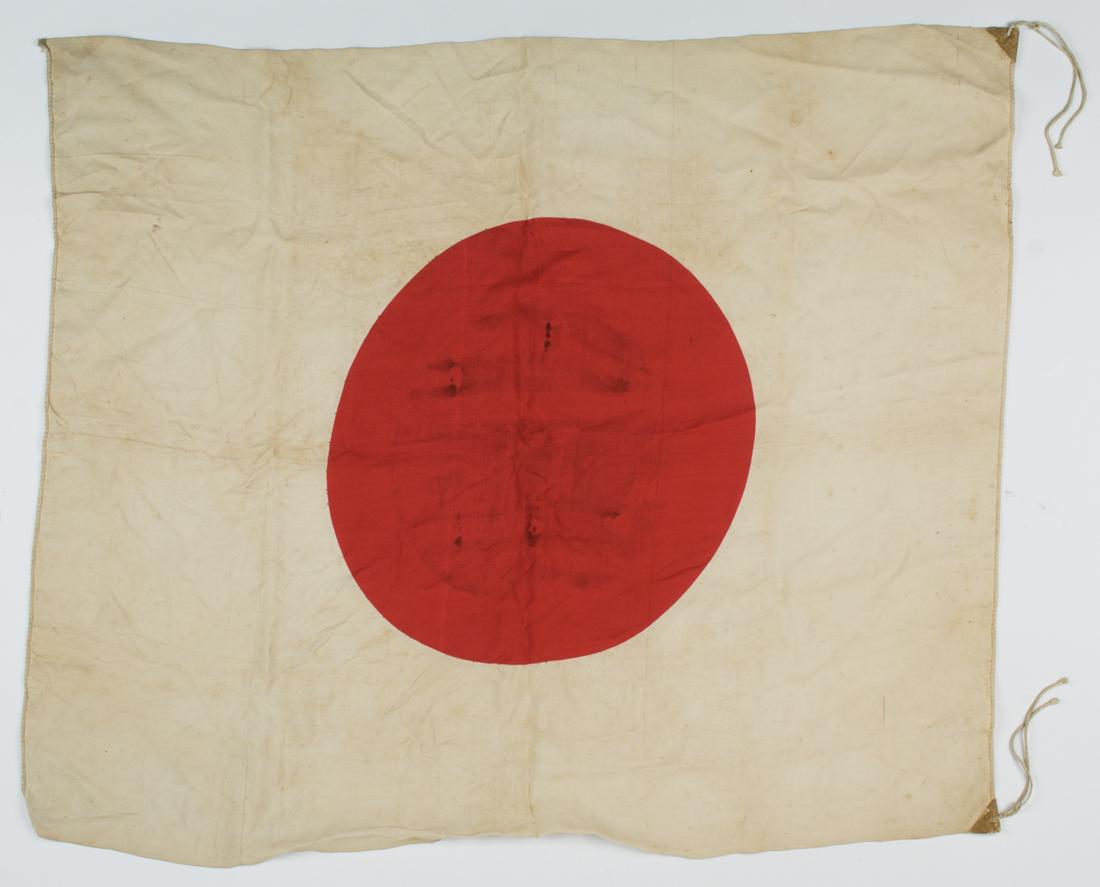 JAPANESE NATIONAL FLAG: Japanese national flag 35 x 30 in. one-piece rayon construction and likely war-date with cloth reinforcing tabs along the hoist. A few stains as one would expect else very good.