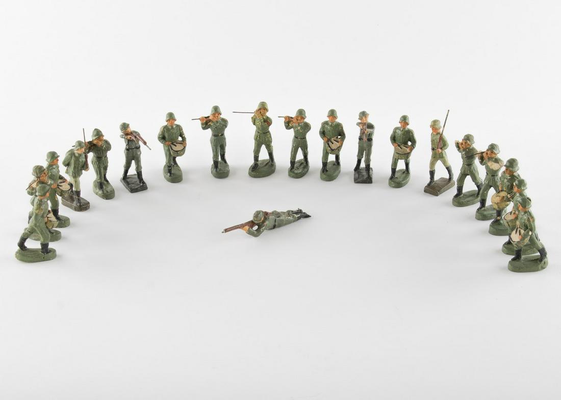WEHRMACHT MARCHING BAND TOY SOLDIERS: WEHRMACHT MARCHING BAND TOY SOLDIERS Lot of 20 period toy soldiers each 2.75 in. tall showing Wehrmacht soldiers in uniform. Most hold instruments in their hands likely as part of a military marching 