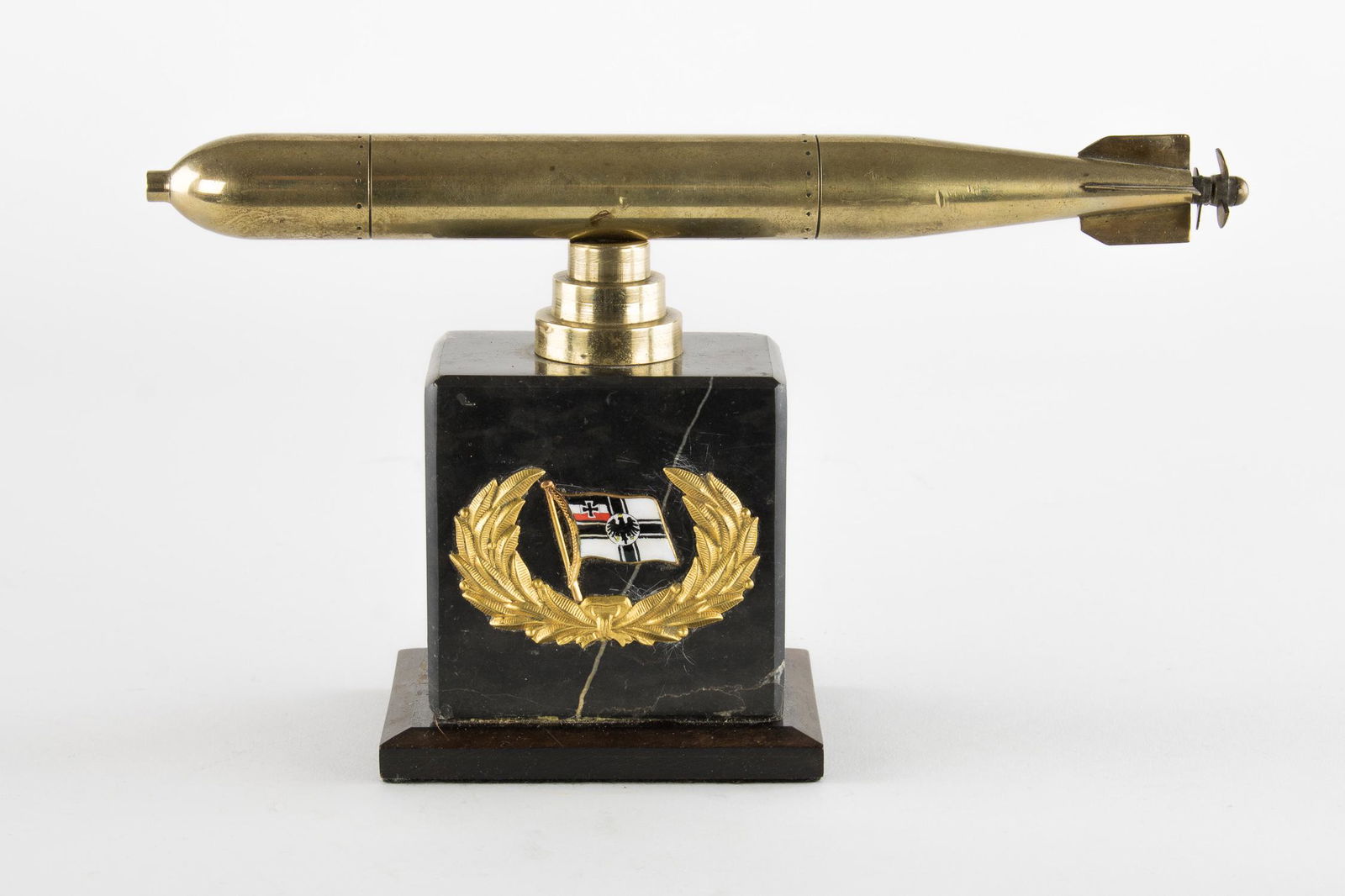 GERMAN PRESENTATION MOUNTED TORPEDO DISPLAY: A finely crafted presentation: a detailed 10 in. long solid brass propeller mounted atop a 3.25 x 2.25 x 3 in. black marble base which itself rests upon a dark finished wood base. The marble baser bea