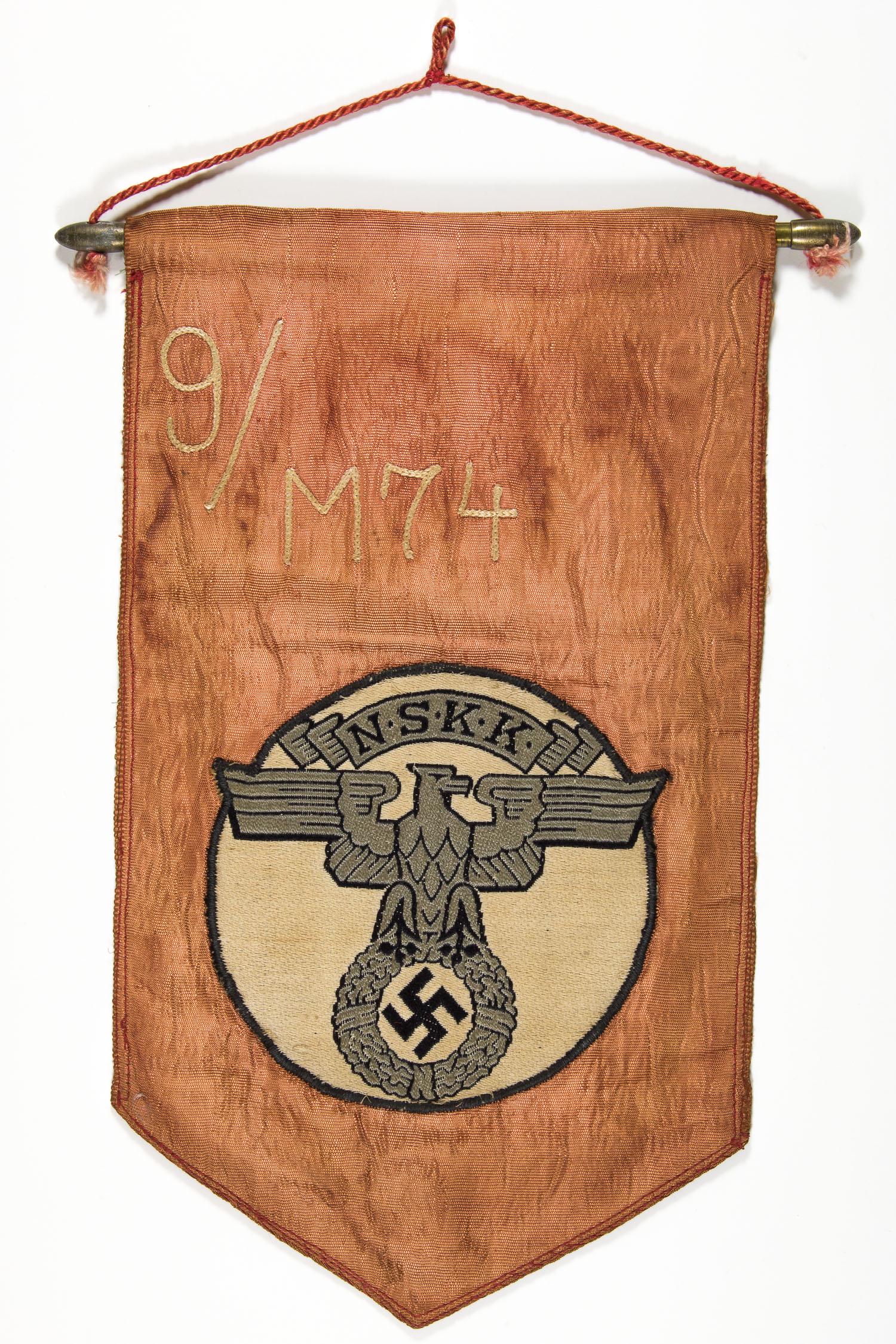 N.S.K.K. DESK FLAG WITH STAND: N.S.K.K. DESK FLAG WITH STAND Rare N.S.K.K. desk flag with wooden stand. The rayon flag 11.5 in. tall and 6.75 in. wide is constructed of heavy red moire rayon with a 5 in. wide NSKK emblem expertly e