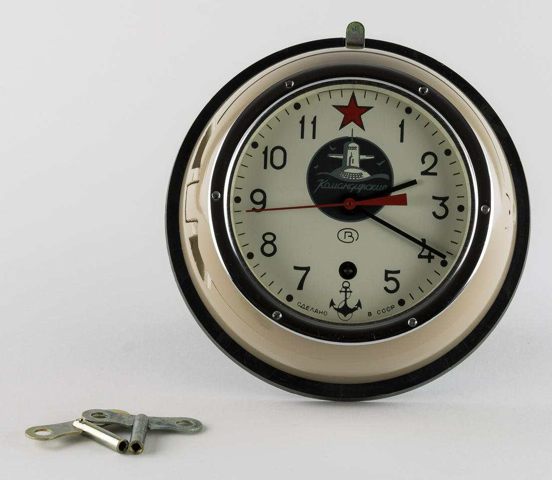 SOVIET VOSTOK SUBMARINE CLOCK: Vostok Soviet Russian 5-24M "submarine" clock 9.5 in. dia. x 3.75 in. height bears a 5.5 in. painted metal dial with grey Arabic hours a red star for 12 and anchor for 6 centered with the painted subm