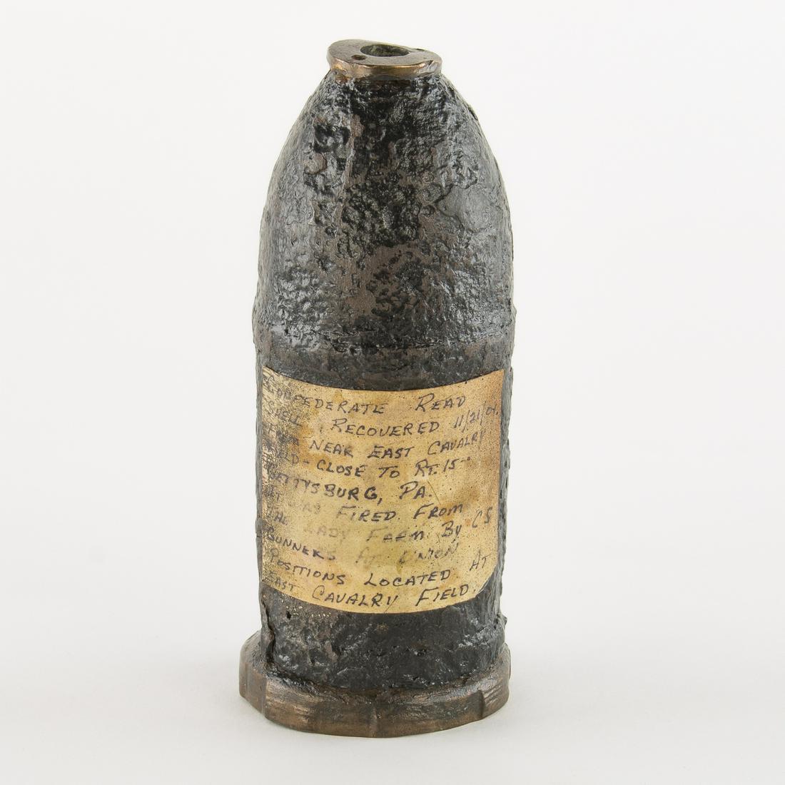 EXCAVATED CONFEDERATE READ SHELL, RECOVERED NEAR: A fine Civil War Relic a Confederate 10lb. read shell 8 in. x 3 in. dia. lacking its fuse yet retaining its copper sobot ring. An affixed label on the side reads in full: "Confederate Read shell 