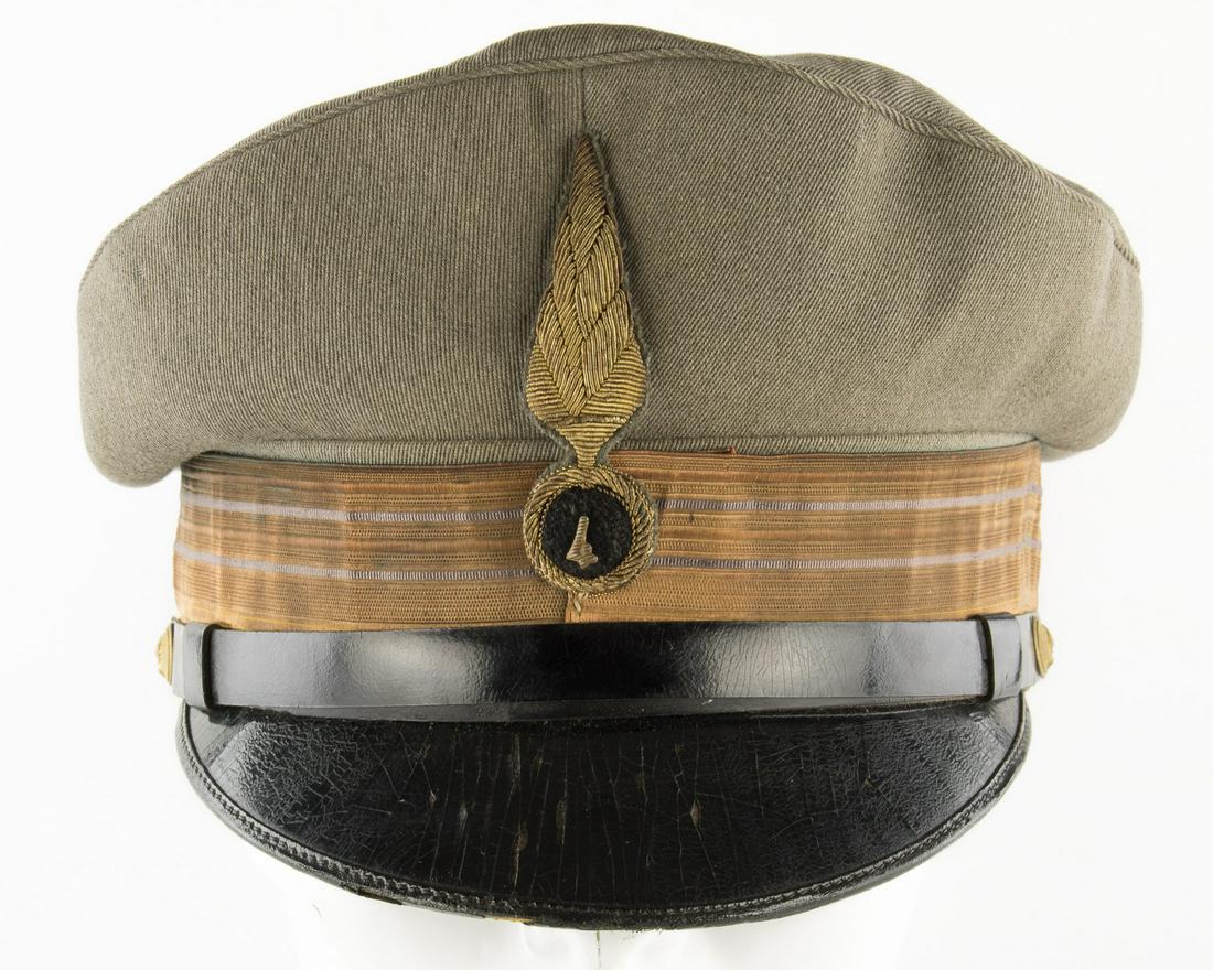 ITALIAN CAVALRY OFFICER'S CAP: Italian cavalry officer's visor cap, constructed of grey wool. The insignia at front shows a black velvet disk at center bearing the regimental number '4' atop a gold bullion motif of a flaming bomb.
