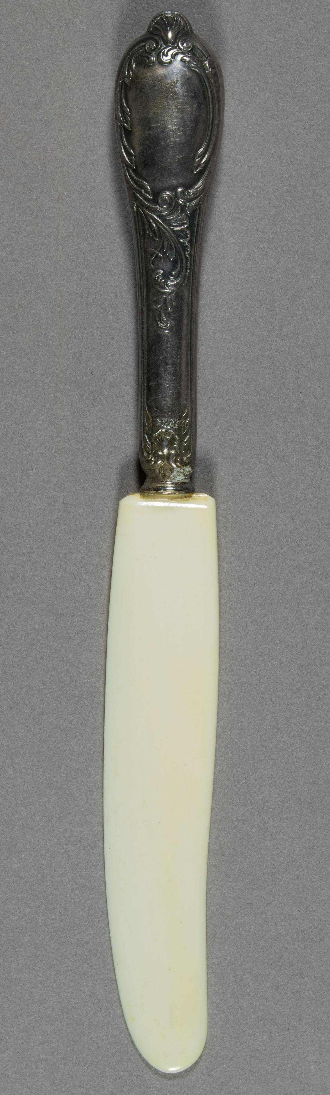 HERMANN GORING SILVER AND IVORY-COLOR FRUIT KNIFE: Very rare silver fruit knife with ivory-colored blade from a set once owned by Reichsmarshal Hermann Goring, 8.25 in. long overall, a fanciful baroque-style handle lightly engraved with the German nat