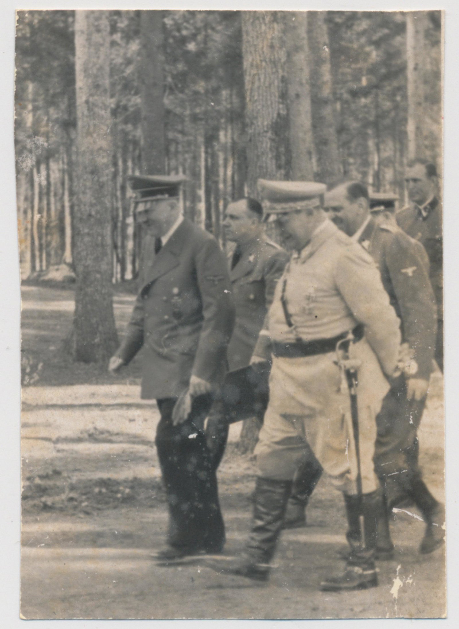 HITLER AND GOERING AT THE 'WOLF'S LAIR': Original photograph, 2 x 3 in. b/w, showing Adolf Hitler and Hermann Goering walking side-by-side at the 'Wolf's Lair', with a dress sword notably hanging at Goering's hip. Fine.