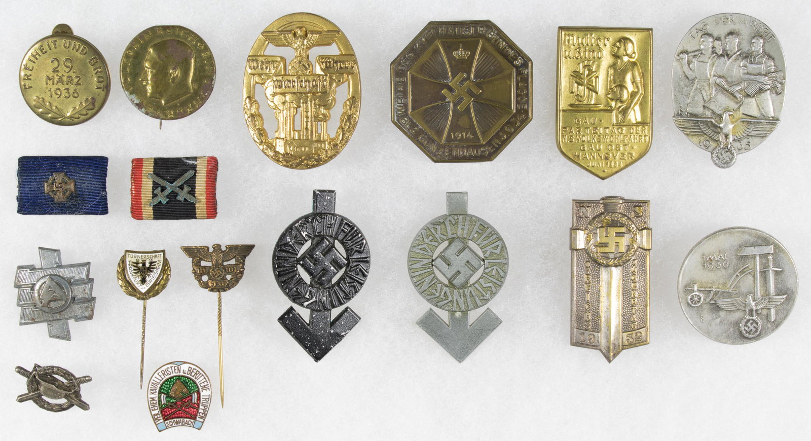 THIRD REICH PINS AND TINNIES (17): Large grouping of varied German pins, tinnies, etc. includes: 1932 Reich Jugendtag pin, 1935 Tag der Arbeit pin, 1 Mai 1936 pin, 'Wehr Fuhrer Wirtschaft' pin, 'Mutter u. kind' pin (lacks pin), S.A. pi