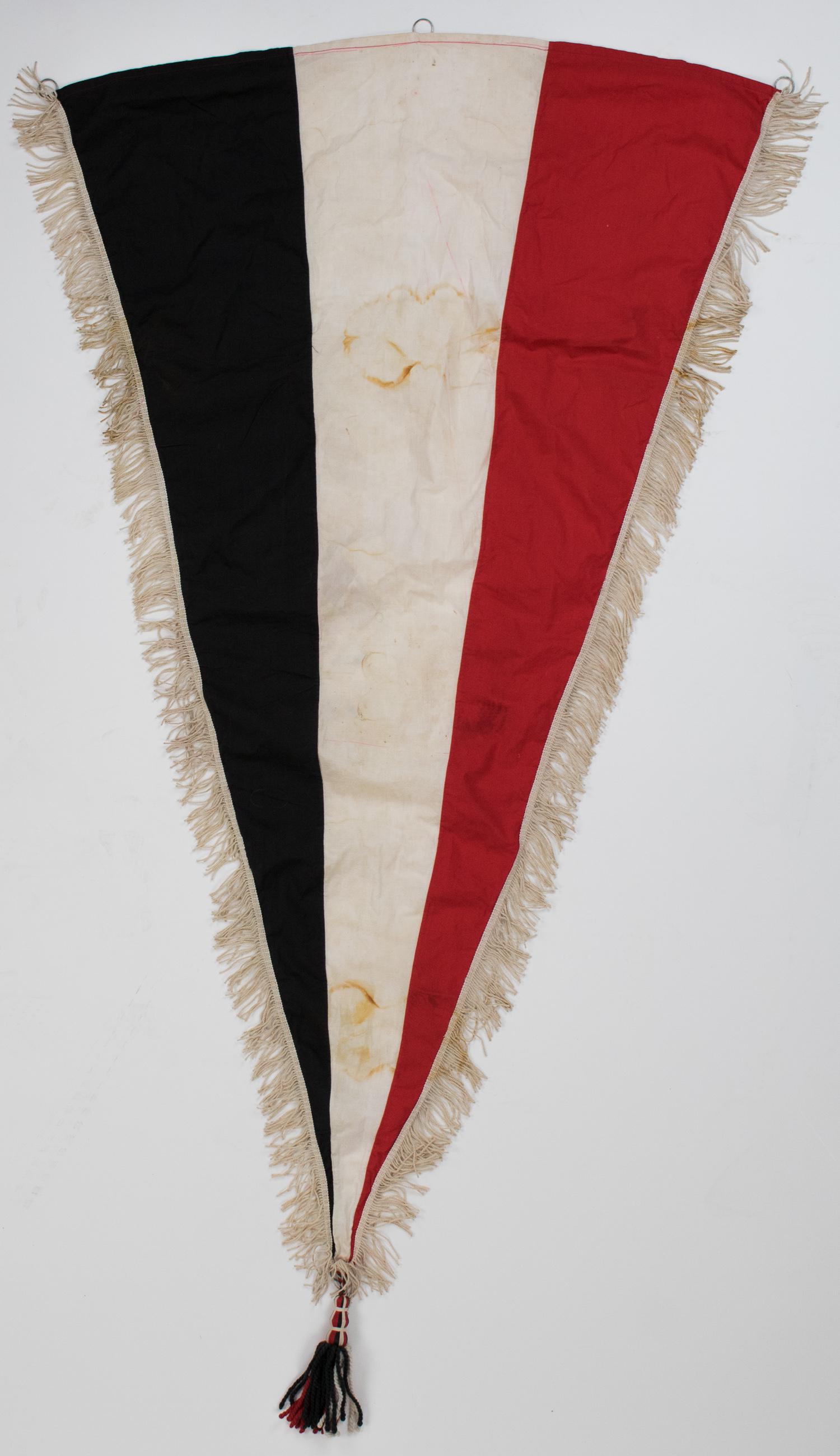 IMPERIAL GERMAN PENNANT: Large pennant from Imperial Germany, 32 x 55 in., constructed of three bars of red, white, and black cotton. The hoist end bears three metal hoops for hanging, while the other two edges bear 2 in. fri