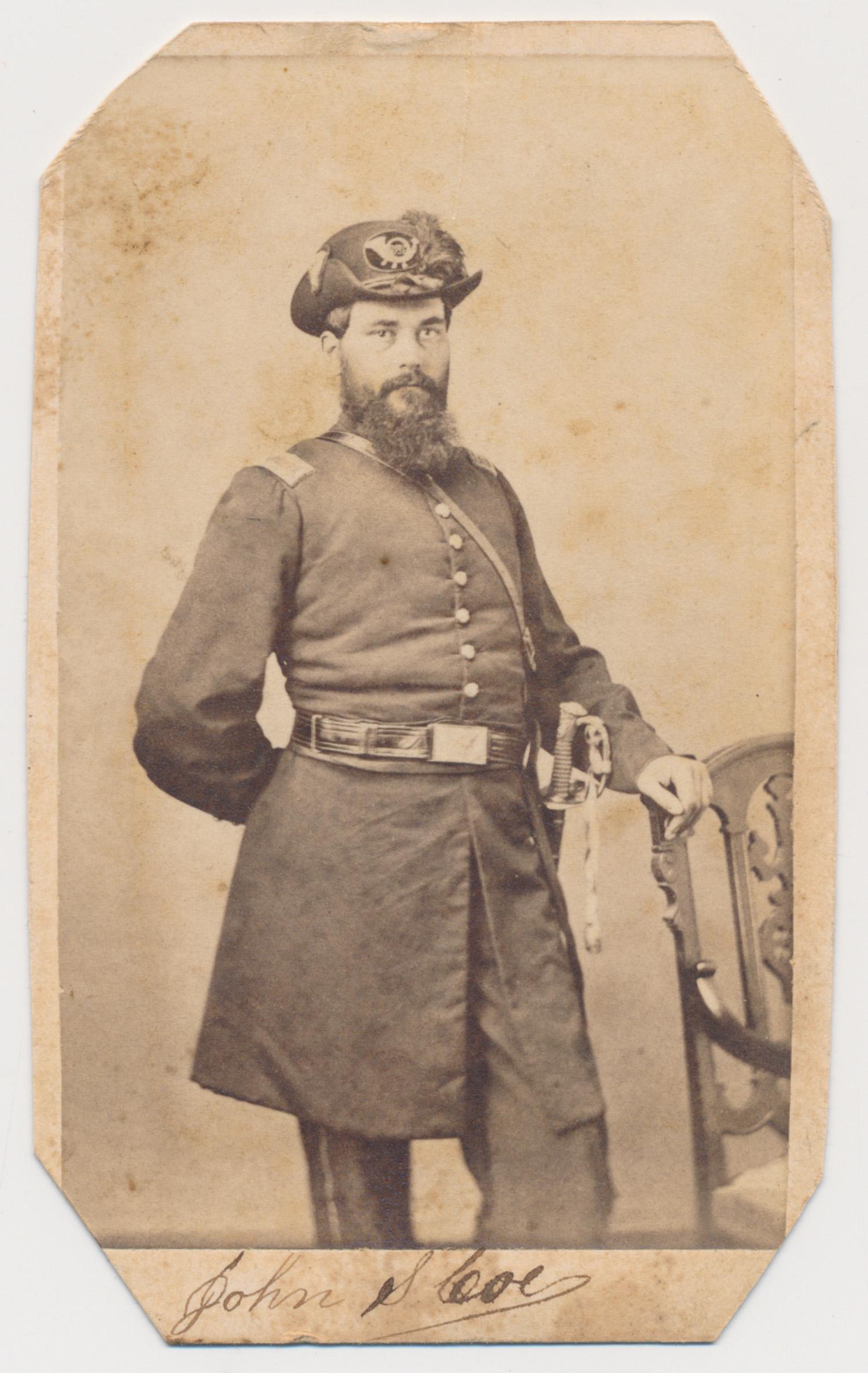 CAPT. JOHN S. COE, 111TH N.Y. VOLS.: Signed carte de visite photograph of Capt. John S. Coe, 111th N.Y. Vols., showing him in uniform with sword at his side. Photo credited to S. M. Fassett, Chicago. Corners clipped, some soiling. The 11