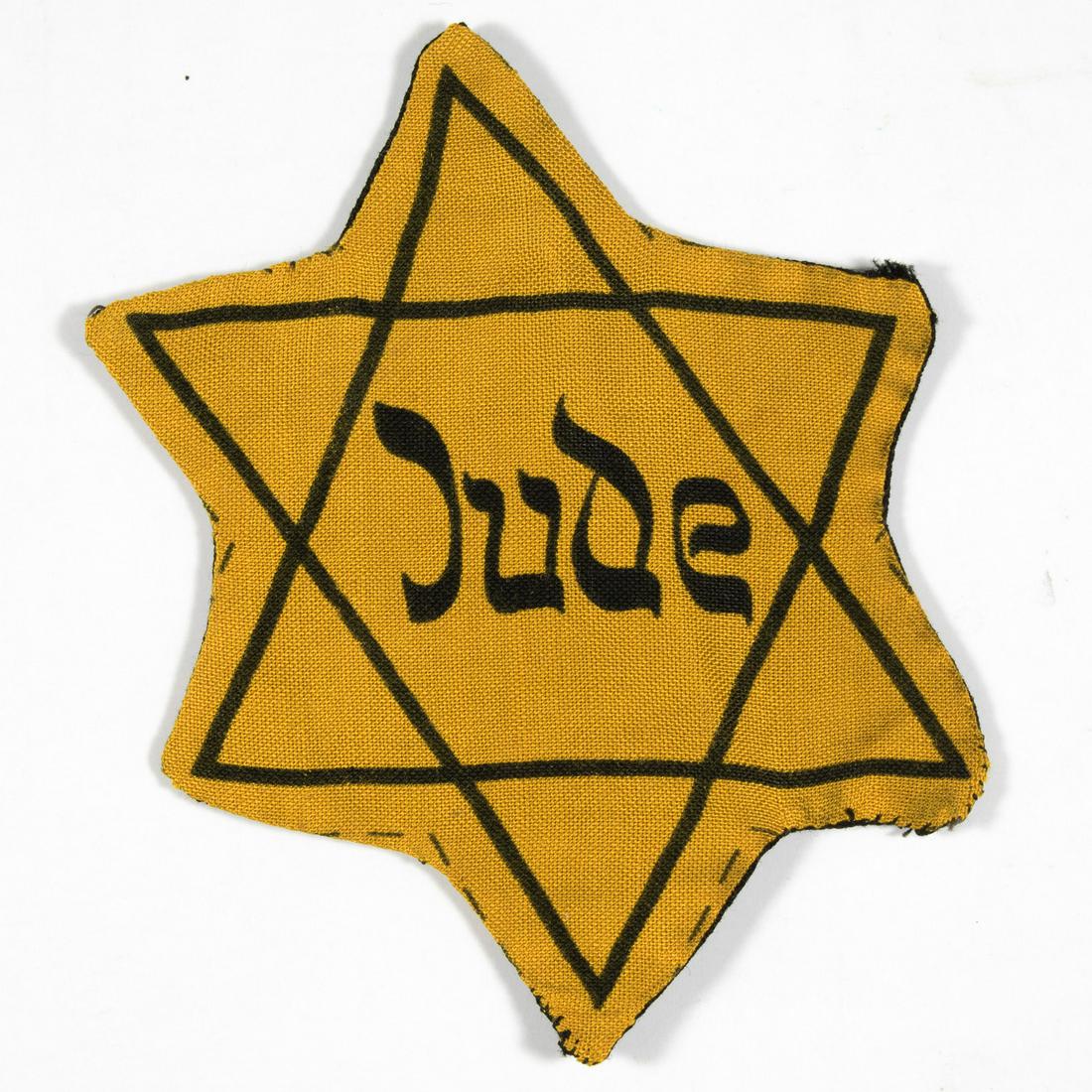 GERMAN 'JUDE' CLOTH STAR OF DAVID: Yellow cloth Star of David imprinted 'Jude', 3.5 in. diameter, in correct yellow cloth color and weave, very heavily printed in black. The star had been hand-stitched to a black cloth backing and was 