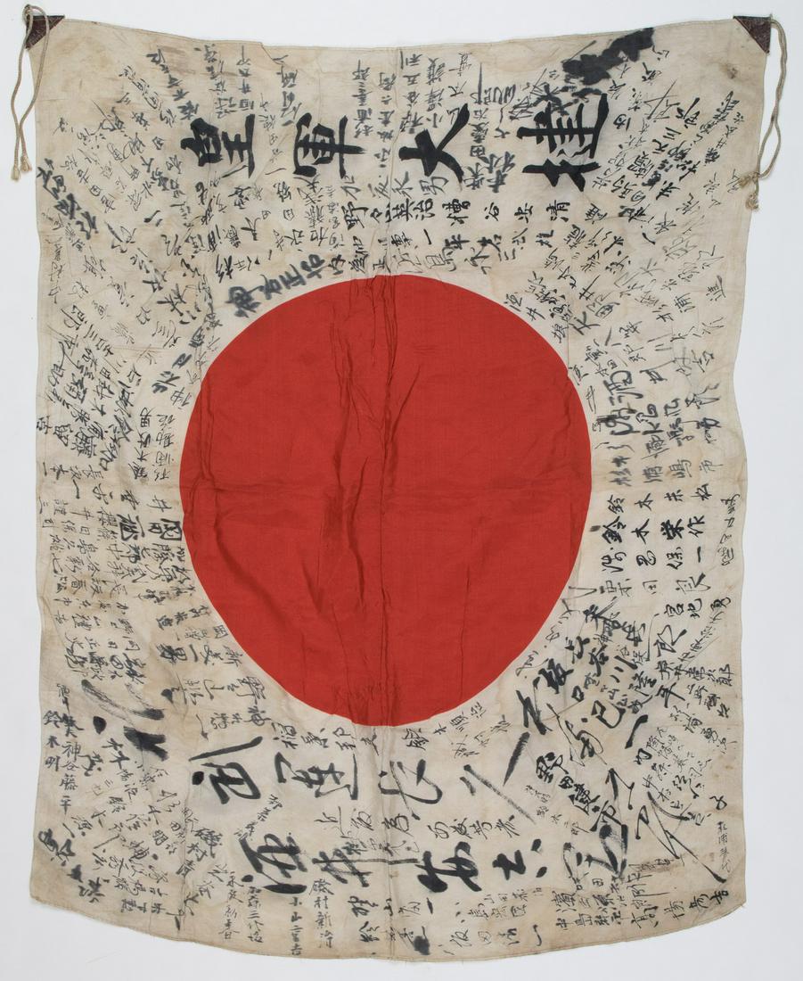 JAPANESE SOLDIER'S GOOD LUCK FLAG: White rayon flag, 32 x 26 in., clamp-dyed with a red Japanese 'meatball' sun symbol at center. The white field of the flag is completely filled with Japanese inscriptions in black ink radiating outwar