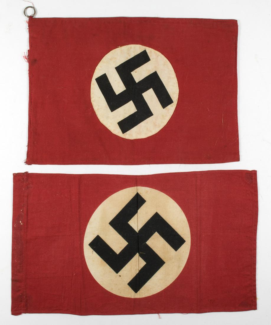 N.S.D.A.P. FLAGS: Pair of small N.S.D.A.P. flags, one of heavy duty two-part construction, 11 x 8 in., lacking one ring and with a small tear at the hoist on one side; the second flag a printed design, 13 x 7.5 in. Bot