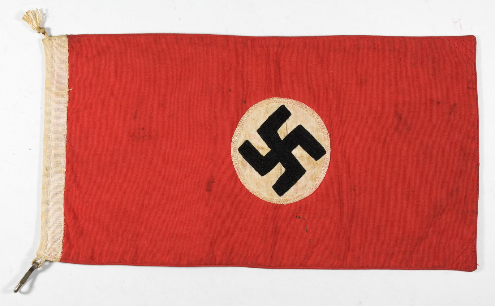 N.S.D.A.P. HARBOR FLAG: Small NSDAP flag possibly used by a small commercial naval vessel, 14 x 7 in., double-sided cotton construction, bearing a tightly-woven mobile swastika on a white disc, embroidered with a white borde
