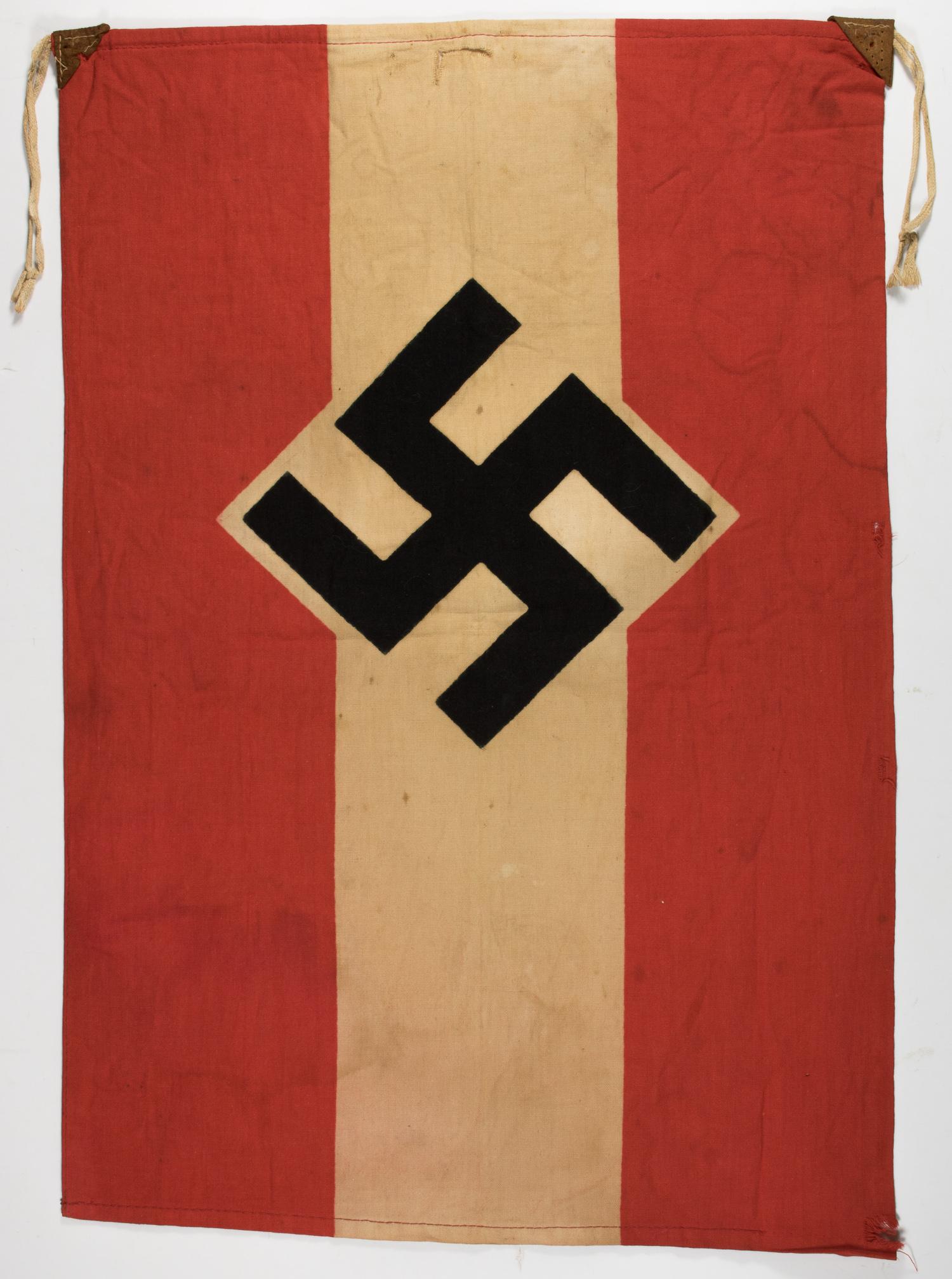 HITLER YOUTH FLAG: Scarce Hitler Youth flag, 19.5 x 13.5 in., double-sided cotton, bearing a clamp-dyed black swastika in the center of a white diamond and a white stripe, all between a red field. The hoist corners bear