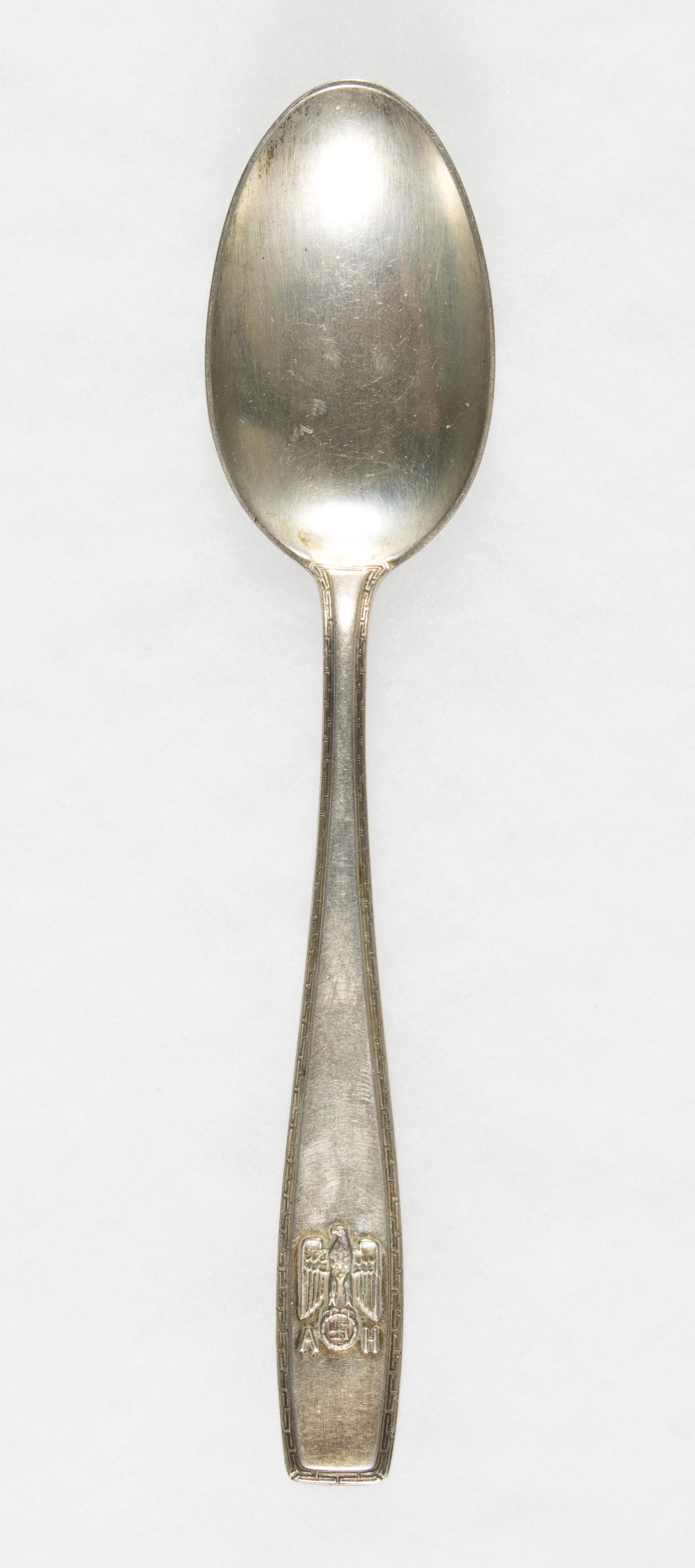 ADOLF HITLER FORMAL SPOON: Rare silver spoon from a personal set of Adolf Hitler's silverware, 7.25 in. The handle is bordered with the Greek key pattern, the end of the handle bearing the national eagle with swastika at bottom