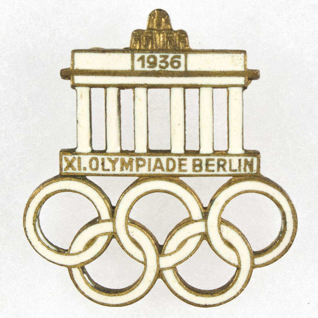 1936 BERLIN OLYMPICS VISITOR'S BADGE: Official visitor's badge to the 1936 Berlin Olympics, 1.25 square in., pin-on type, depicting the white enameled Brandenburg Gate above the Olympic rings. The reverse bears a horizontal straight pin a
