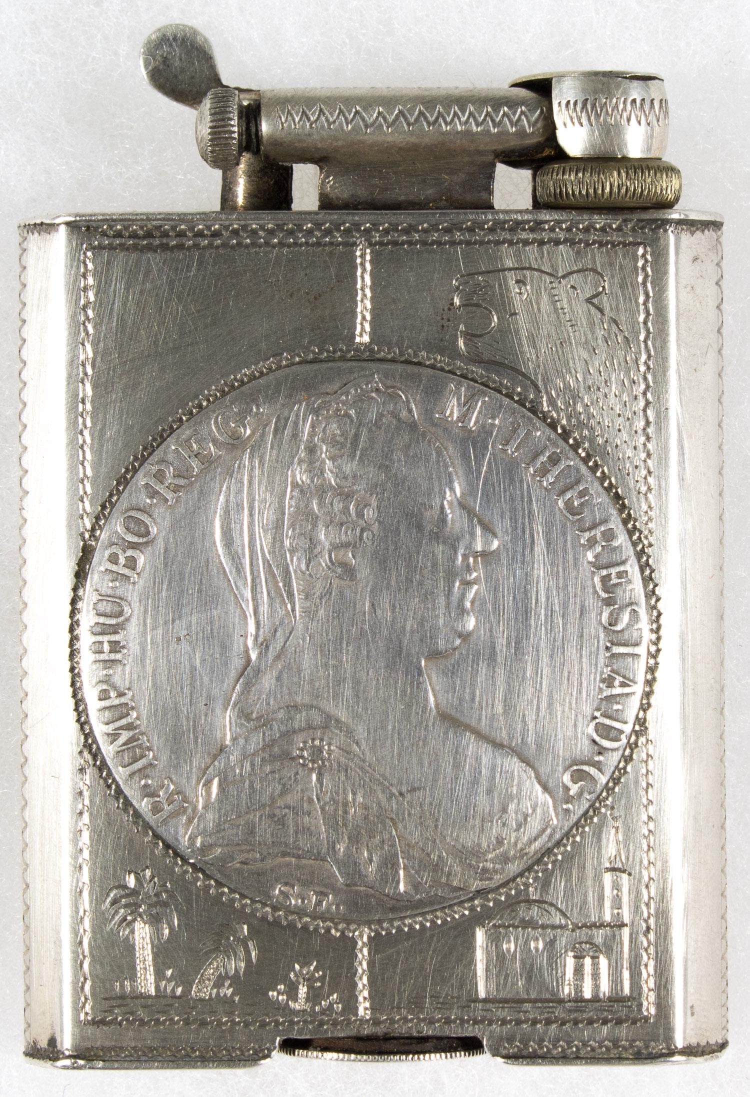 MARIA THERESA REICHSTHALER NORTH AFRICAN LIGHTER: An intriguing souvenir lighter, a 2 x 2.75 in. North African hand-worked silver lighter bearing the obverse and reverse of a 1780 Maria Theresa silver thaler, typically used as a bullion trade coin th
