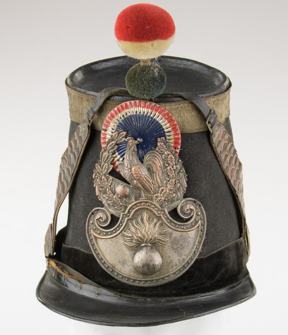 FRENCH REVOLUTION ARTILLERY SHAKO: French artillery shako used during the French Revolution, ca. 1848, bearing 7.25 in. tall dark blue felt body, with an aluminum 'French colors' rosette on the front panel. Beneath this is a front plat