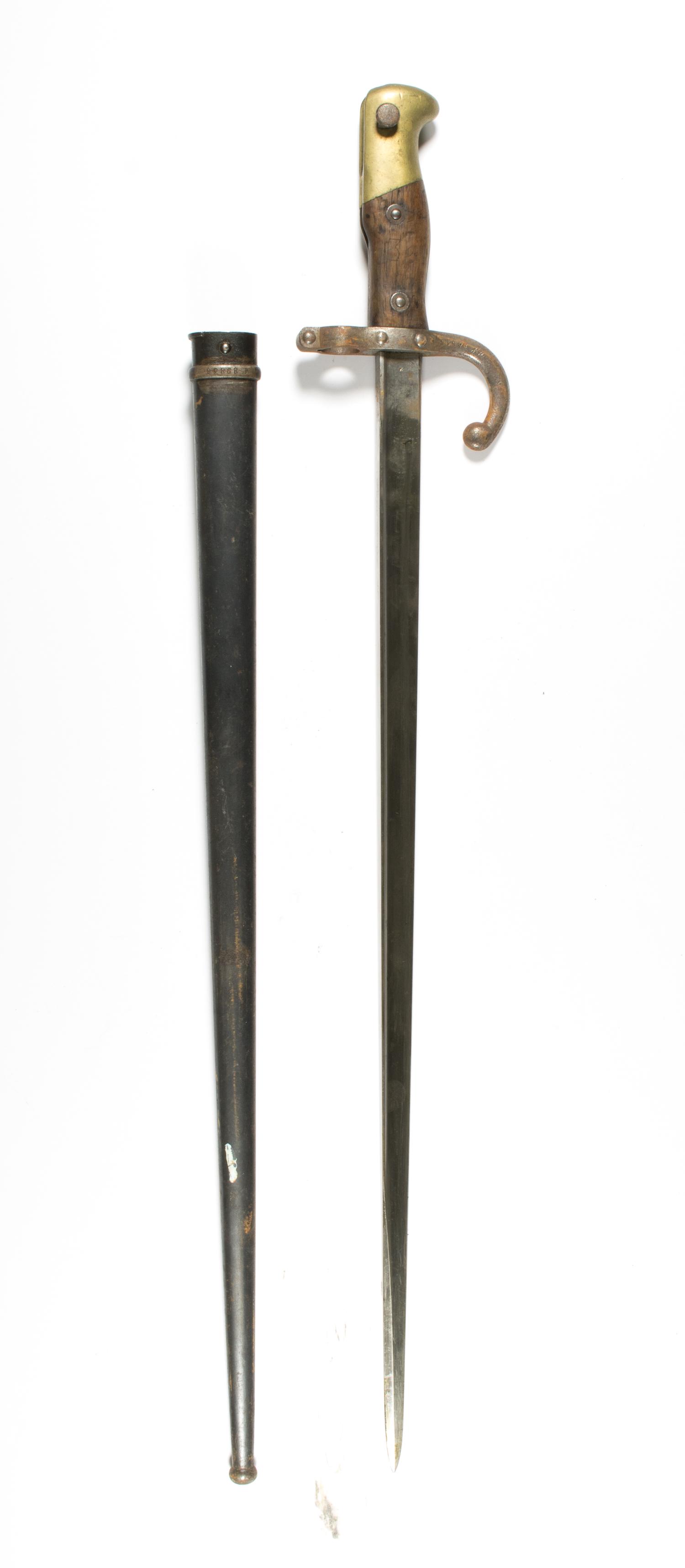 FRENCH M1874 GRAS BAYONET: A late nineteenth century French bayonet for the Gras rifle, 20.5 in. blade, 27.5 in. overall, with wood grip and curved cross guard, housed in a black metal scabbard. No maker's marks present due to 