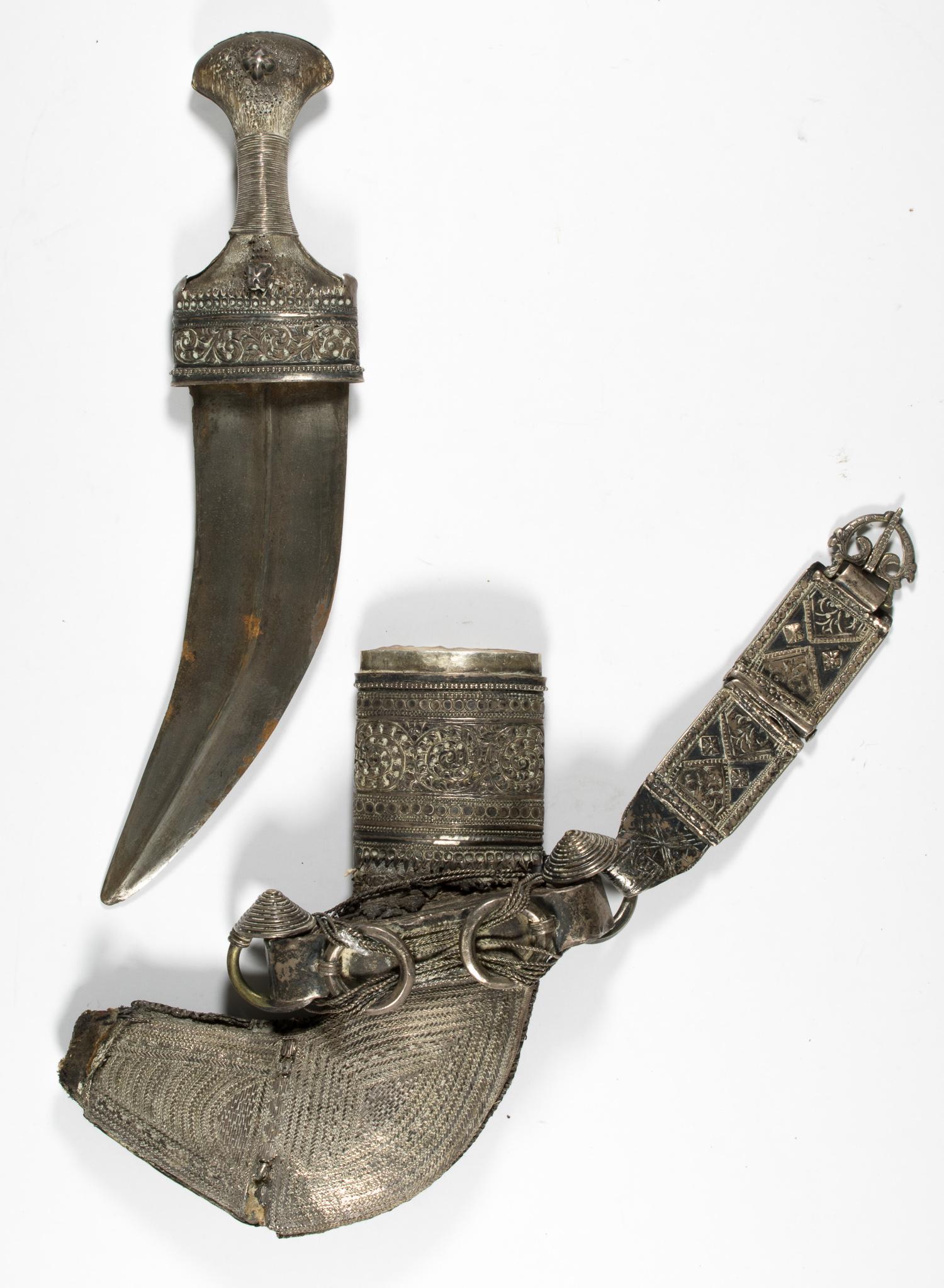 OMAN KHANJAR DAGGER: Antique Omani silver Khanjar dagger, ornate silver fabric and wire on wood with hide covering, very ornate clasps and decoration, blade approx. 8 in. long. Worn, the tip of the scabbard badly abraded,