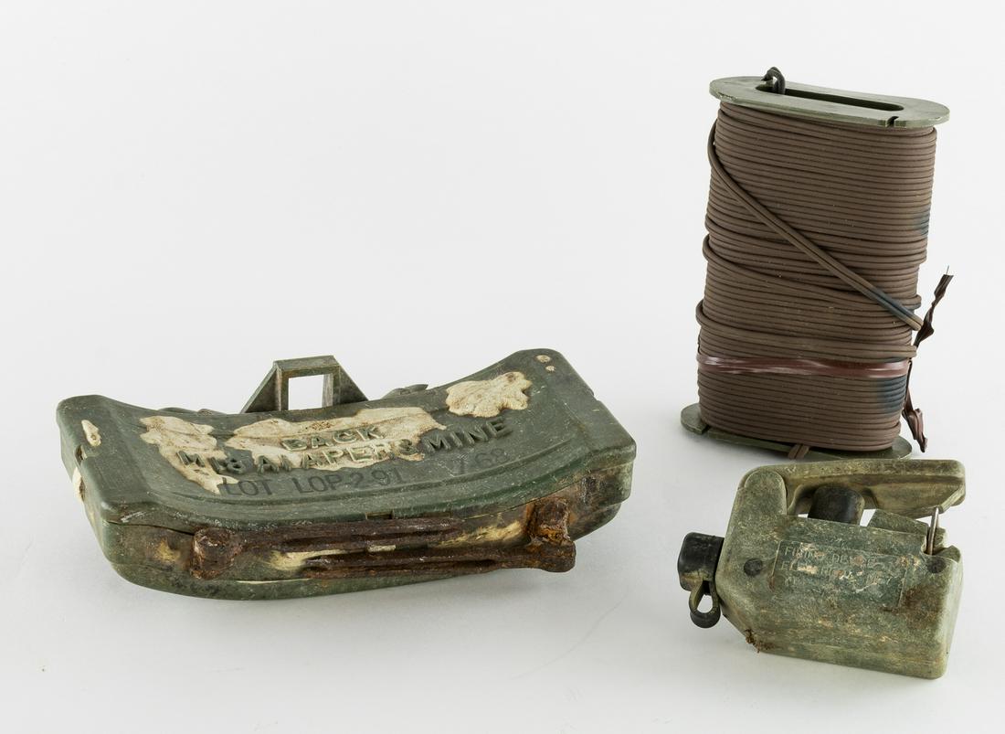 M18A1 CLAYMORE MINE, WIRE, SWITCH, AND CARRY BAG: Rarely seen genuine American M18A1 Claymore antipersonnel weapon. This example, recovered in Vietnam, measures approx. 9 x 5 x 2 in. The front of the plastic case bears the instruction: 'FRONT TOWARD 
