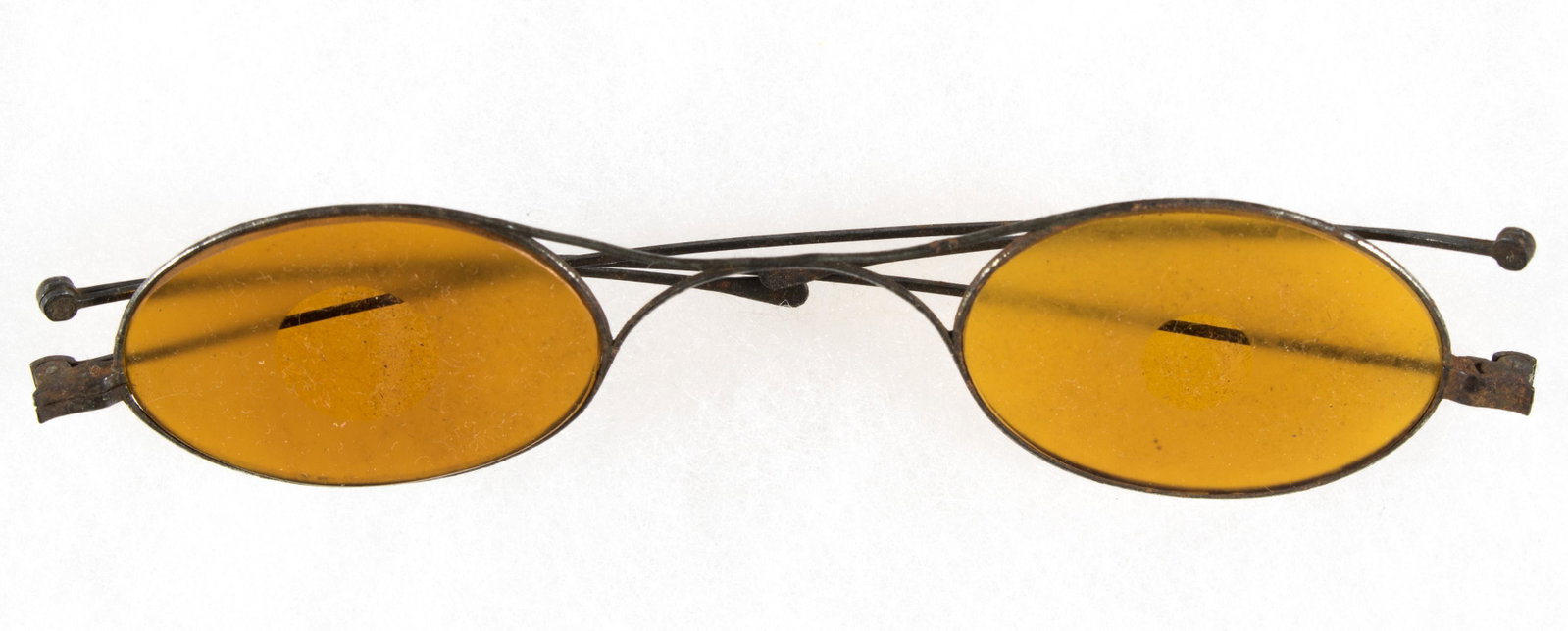 CIVIL WAR SNIPER'S GLASSES: Cased pair of Civil War sniper's glasses, iron frames with folding arms, the lenses yellow to accentuate the light entering and entirely frosted but for the center to eliminate reflection which could 