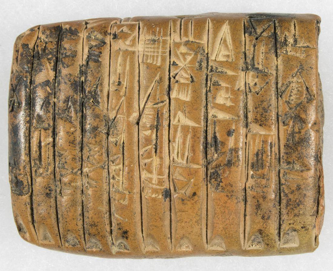 CUNEIFORM CLAY TABLET: A fine example of one of the earliest writing systems in history, a 2 x 1 in. clay tablet inscribed on both sides with cuneiform writing, the language of the ancient Sumerians who inhabited the region