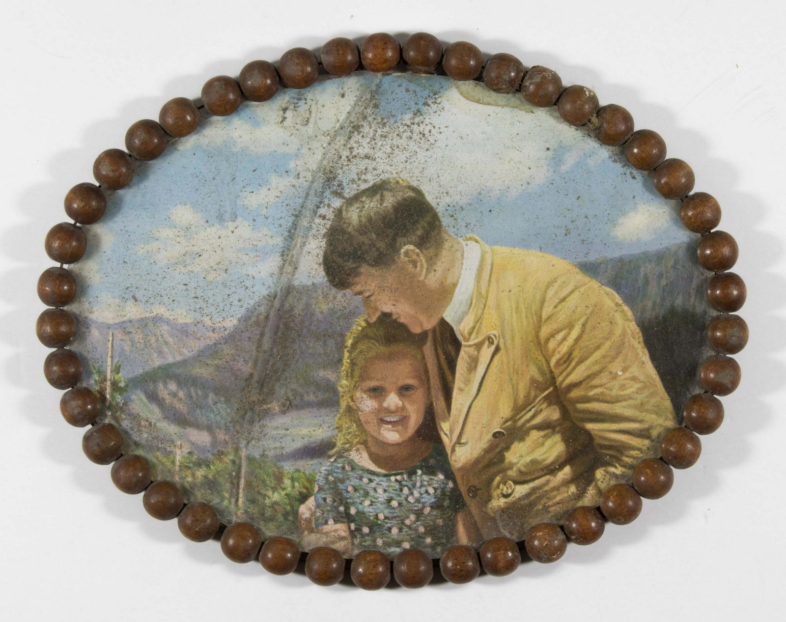 ADOLF HITLER WITH ROSA NIENAU: An artistâ€™s rendition of the famous image depicting Adolf Hitler posing with the young Jewish girl Rosa Nienau, 8.5 x 7 in. (sight), color, housed within an original circular wooden frame. Rosa