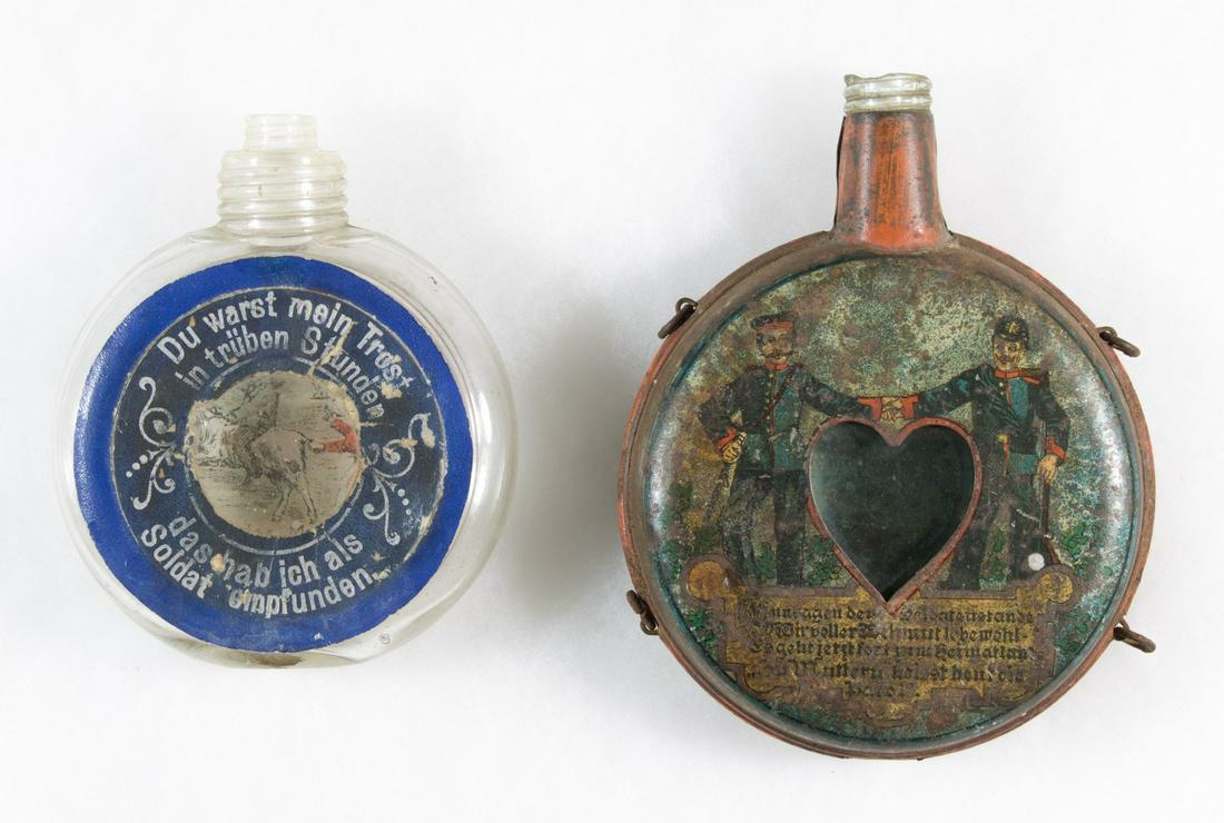 IMPERIAL GERMAN FLASKS: A pair of intricately decorated World War I era German glass regimental flasks, varying sizes, both circular shaped, the first, 4.5 in. diameter, bears the words 'You were my consolation in my darkest