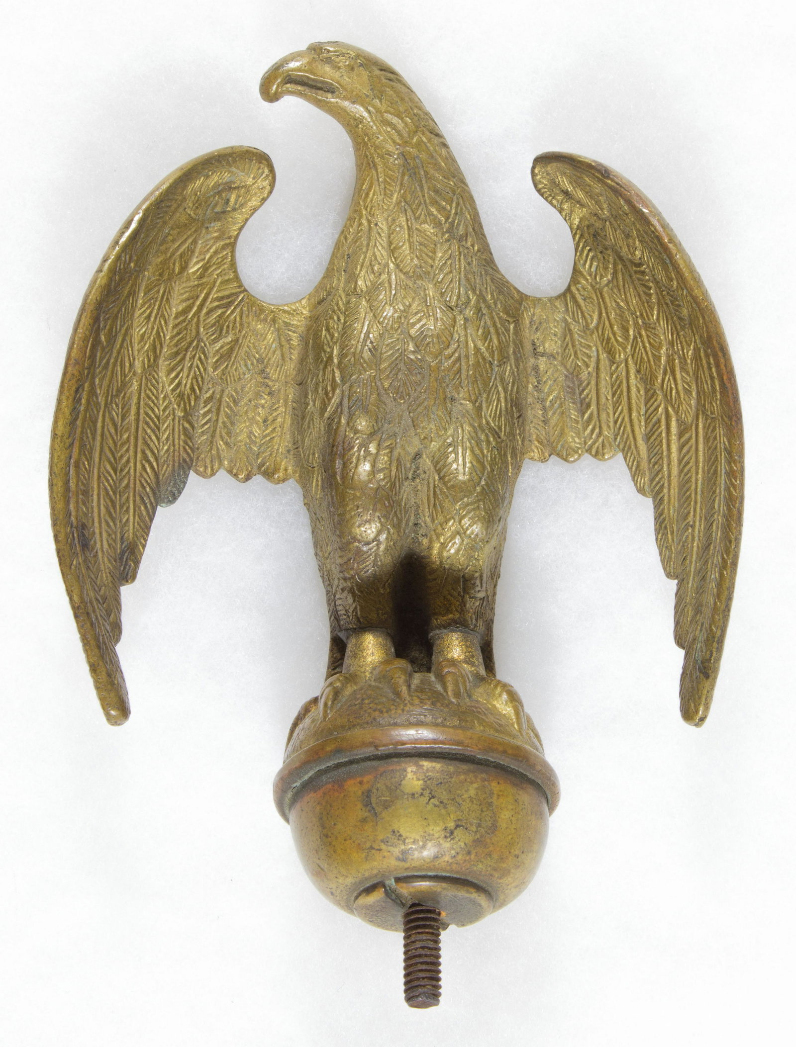 EAGLE POLE TOPPER: Late 19th century brass pole topper in the shape of a finely detailed eagle, approx. 6.5 in. tall, 4.5 in. wide. The perched eagle sits with its wings spread open. A high-quality piece, with no dings,