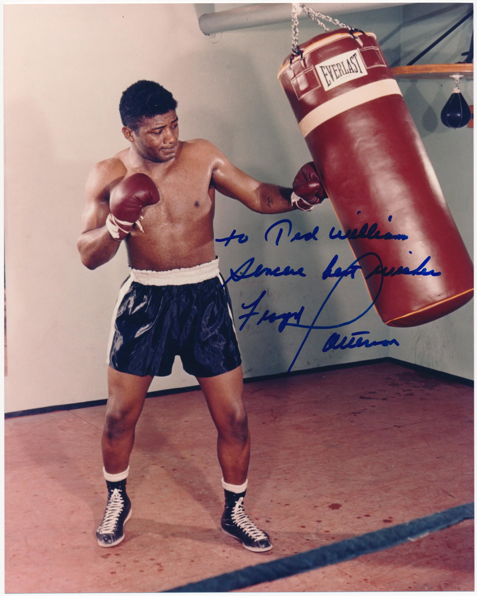 FLOYD PATTERSON: (1935-2006) American heavyweight boxing champion, the first to regain a title after losing it. I.S.P., 8 x 10 in. color, showing Patterson practicing on a punching bag. Boldly signed and inscribed at 