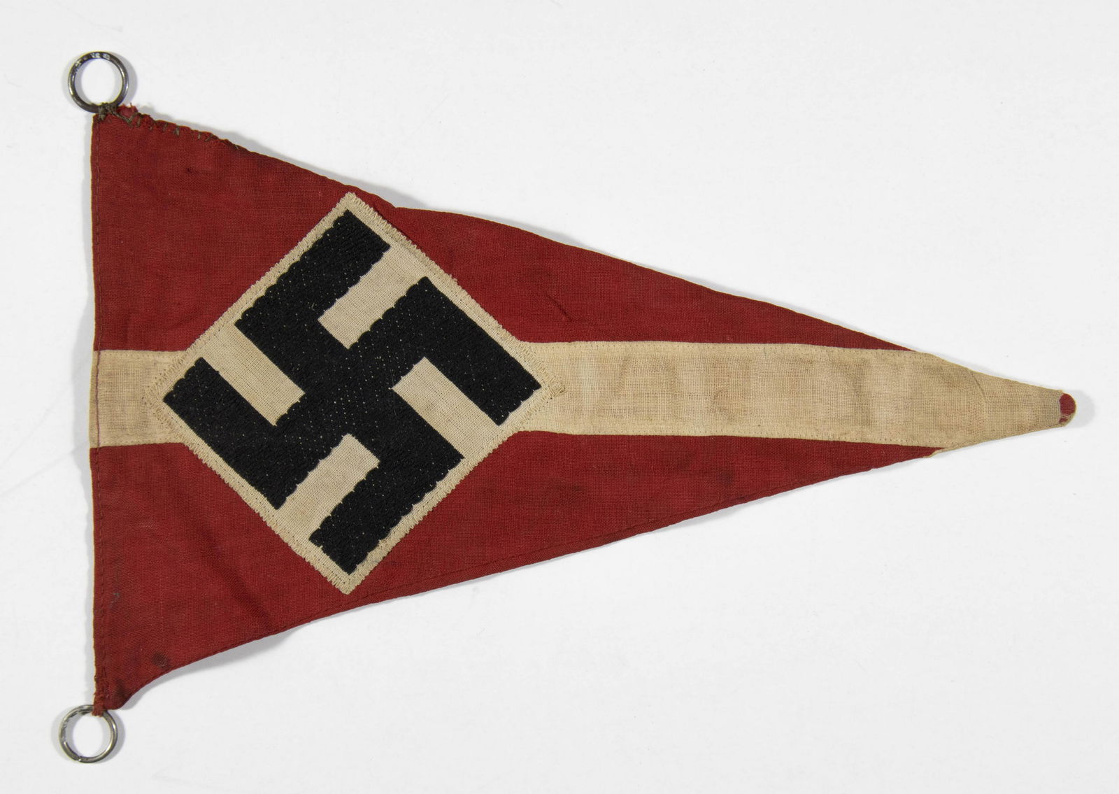 HITLER YOUTH PENNANT: Double-sided Hitler Youth pennant, 9 in. x 5.5 in., bearing a red field with a white horizontal stripe running down the center and a sewn on white diamond with a black mobile swastika. The pennant bea