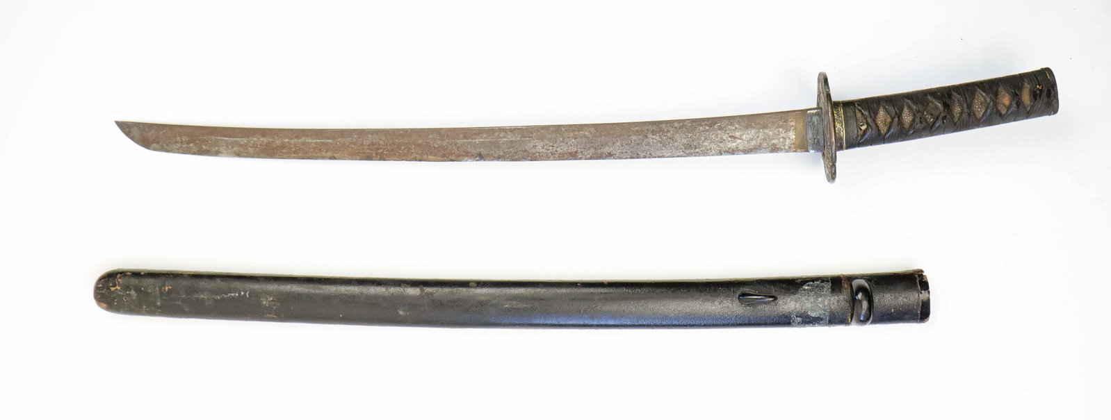 JAPANESE ANCESTRAL BLADE: Japanese ancestral Shin-Gunto, measuring 21 in. from the 'kissaki' (‘tip') to the ‘habaki' (‘stop'), and 27.5 in. overall. The wood grip is covered with white ray skin which has dark