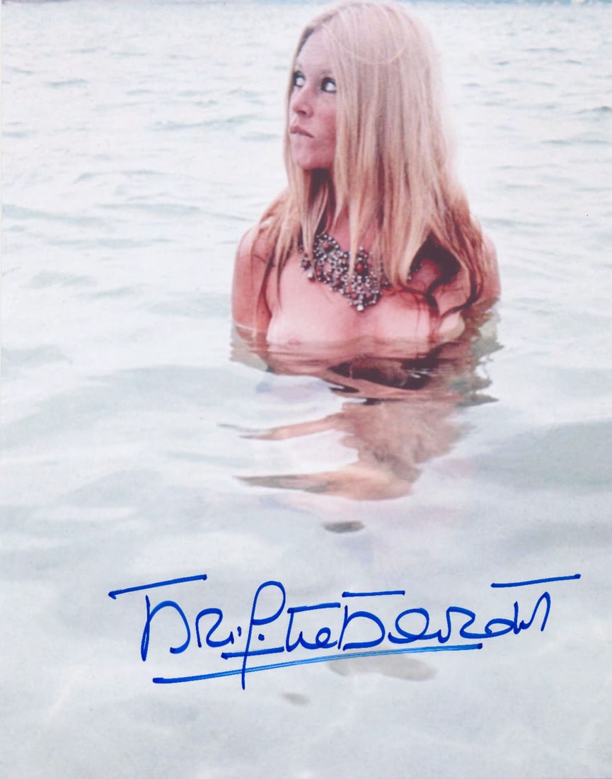 BRIGITTE BARDOT: (b. 1934) French actress, billed as a 'sex kitten'. S.P., 8 x 10 in. color, Bardot poses nude submerged to her chest in water. Boldly signed in blue ink at the bottom. Fine.