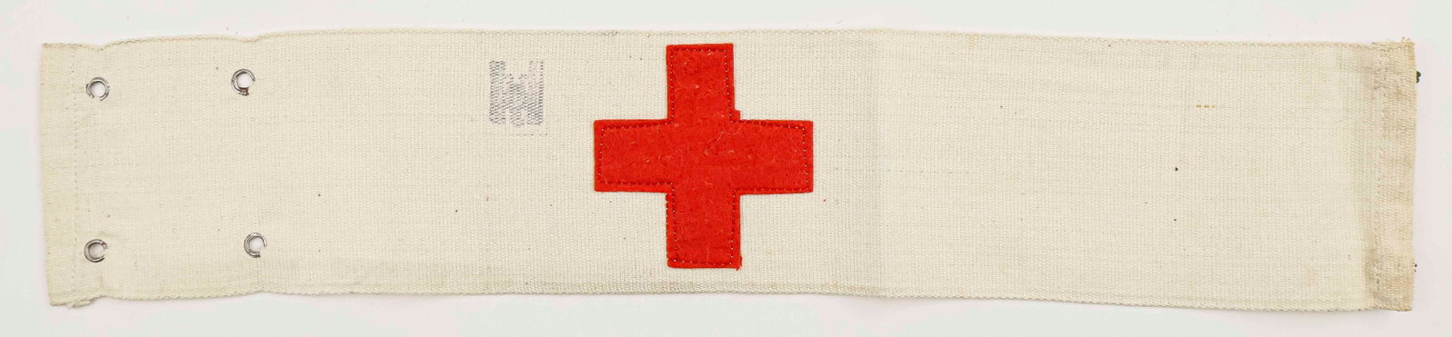 GERMAN RED CROSS ARMBAND: World War II German Red Cross armband, 16 in. long, the felt red cross sewn to the khaki cloth backing. Just next to the red cross is a German eagle stamp, though interestingly lacking the swastika. F
