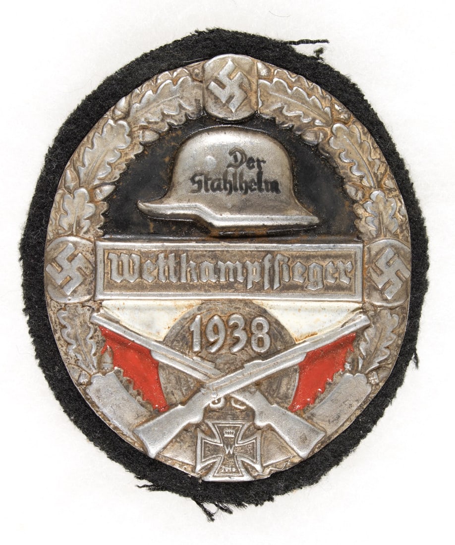 STALHELM SHOOTING FIRST PRIZE BADGE: Attractive cloth and painted metal badge, an award given by the Stahlhelm to the winner of a 1938 shooting competition, 2.75 in. tall, with swastika, Iron Cross, stalhelm emblem, crossed rifles, etc.