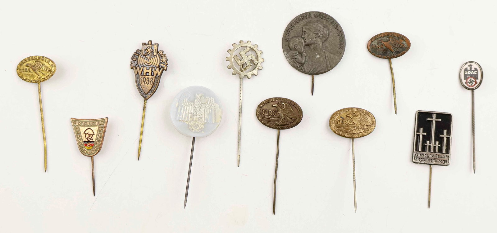 THIRD REICH ERA STICKPIN COLLECTION (10): A collection of 10 stickpins, includes: a WHW 1938 stickpin; silver swastika; an enameled Volksbund pin; D.D.A.C. (German Automobile Club); Fur Den Schutz Military Exercises Farmers and Workers East G
