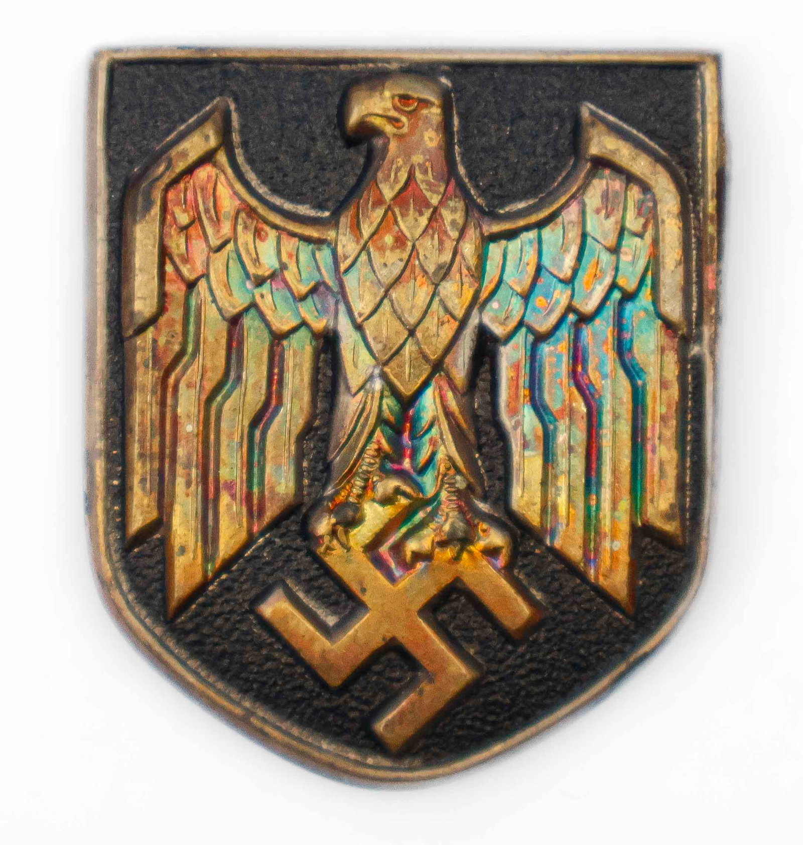 WORLD WAR II AFRIKA KORPS NAVY PITH HELMET SHIELD: Afrika Korps pith helmet insignia shield, featuring a gilded brass eagle and swastika on a black field, 1.5 in. tall. An attractive patina at the wings. Nicely presented in a 2.5 x 3.5 in. riker mount