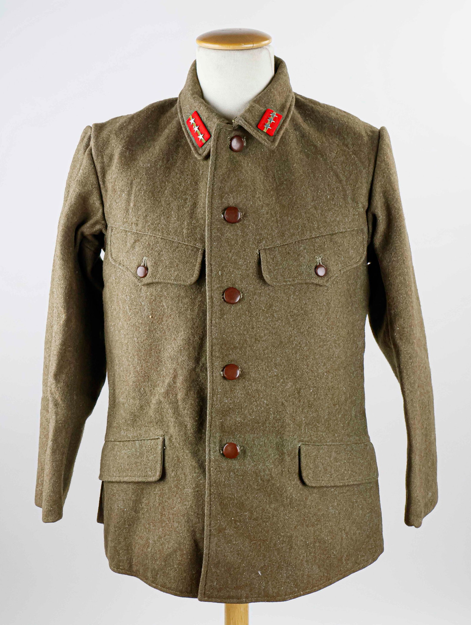 JAPANESE WORLD WAR II OFFICER'S UNIFORM: World War II Japanese Officer's uniform, consisting of a tunic and trousers. The tunic is of OD green wool construction secured closed by five brown plastic buttons and a hook and eye closure at the c