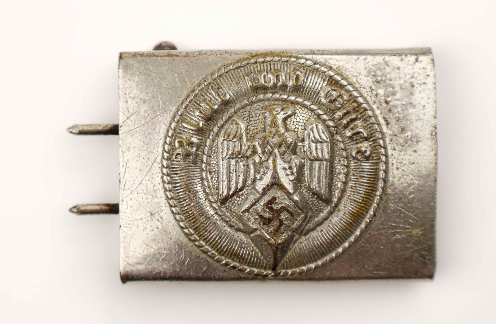 HITLER YOUTH BELT BUCKLE: An early Hitler Youth buckle, 2.5 long, finely polished silver-plated base metal with hooks, bearing an ‘RZM M1/13’ mark. Exhibits moderate scratching and wear, overall good.