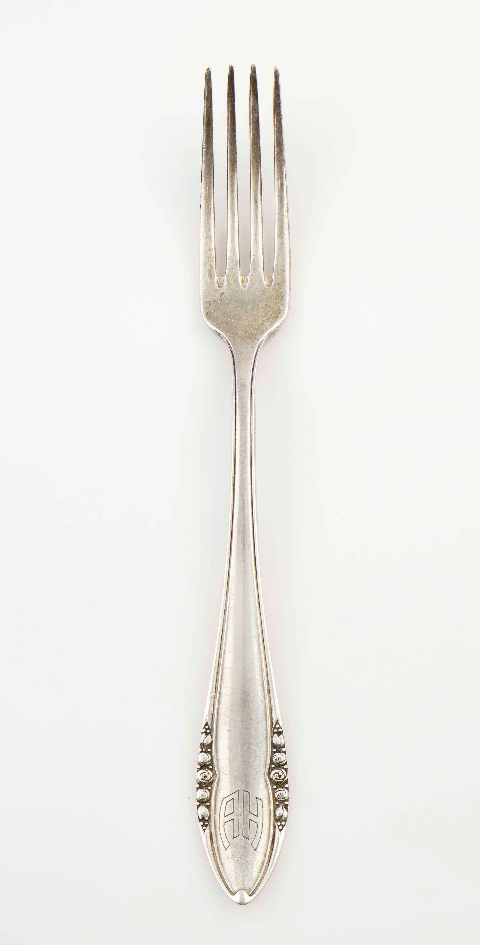 ADOLF HITLER INFORMAL DINNER FORK: An informal silver dinner fork owned and used by Adolf Hitler at non-official, private functions. The four tine fork measures 8.5 in. long and bears his 'A H' 'Berghof pattern' engraved initials at th