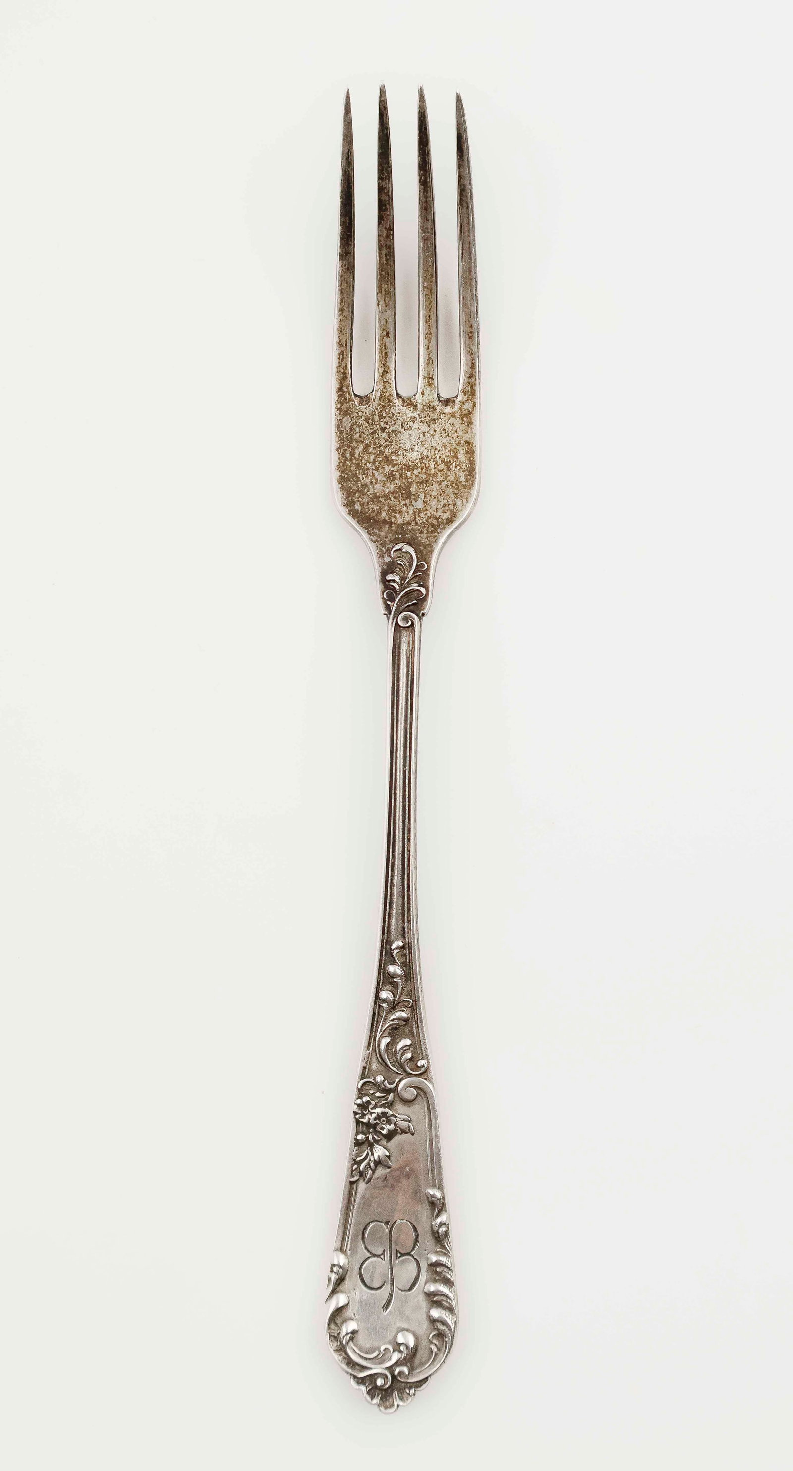 EVA BRAUN SILVER DINNER FORK: An informal sterling silver dinner fork once owned by Adolf's Hitler's wife, Eva Braun. The ornate 7.5 in. four tine fork has an attractive floral and filigree design, along with Braun's period-engrav