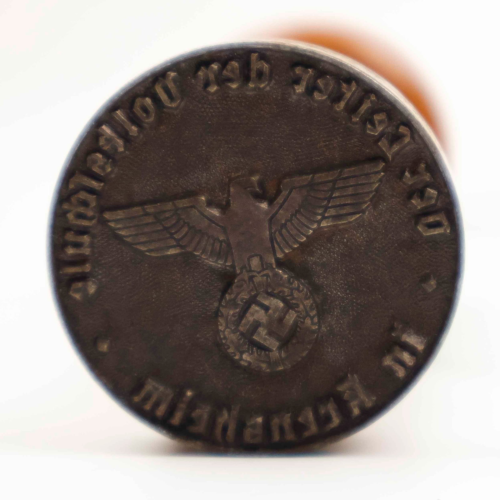 THIRD REICH SCHOOL PRINCIPAL HAND STAMP: Original Nazi stamp for 'Head of the Elementary School', with an eagle device at the middle and text framing the border. The stamp measures 1.33 in. dia. and is established in a 3.75 in., metal stamp 