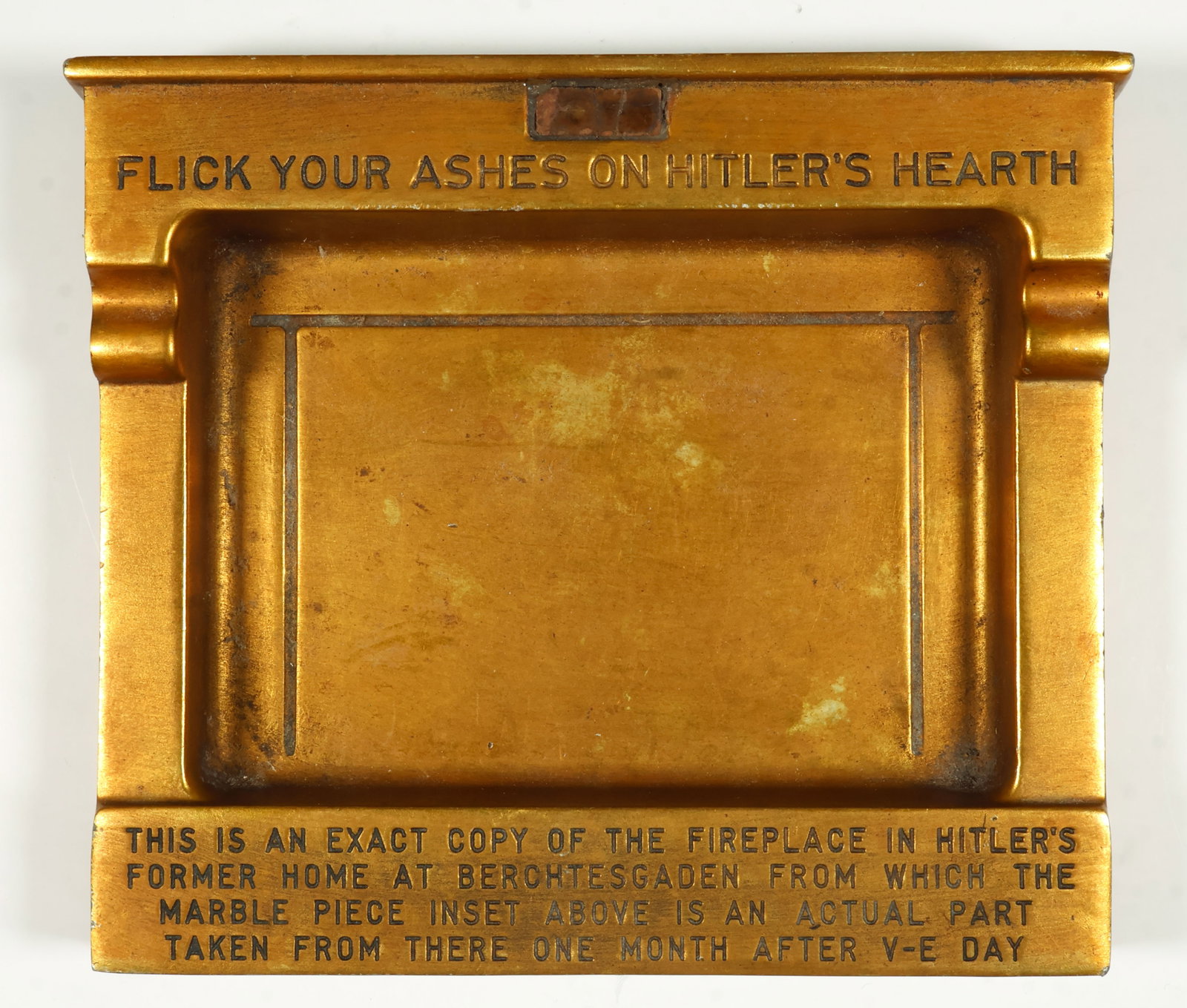 'FLICK YOUR ASHES ON HITLER'S HEARTH': A curious Hitler relic, a solid brass ashtray, 6 x 5.5 x 1 in., a replica of Adolf Hitler's fireplace in the great room at the Berghof. Engraved at the top is the legend: ‘FLICK YOUR ASHES ON HITLER